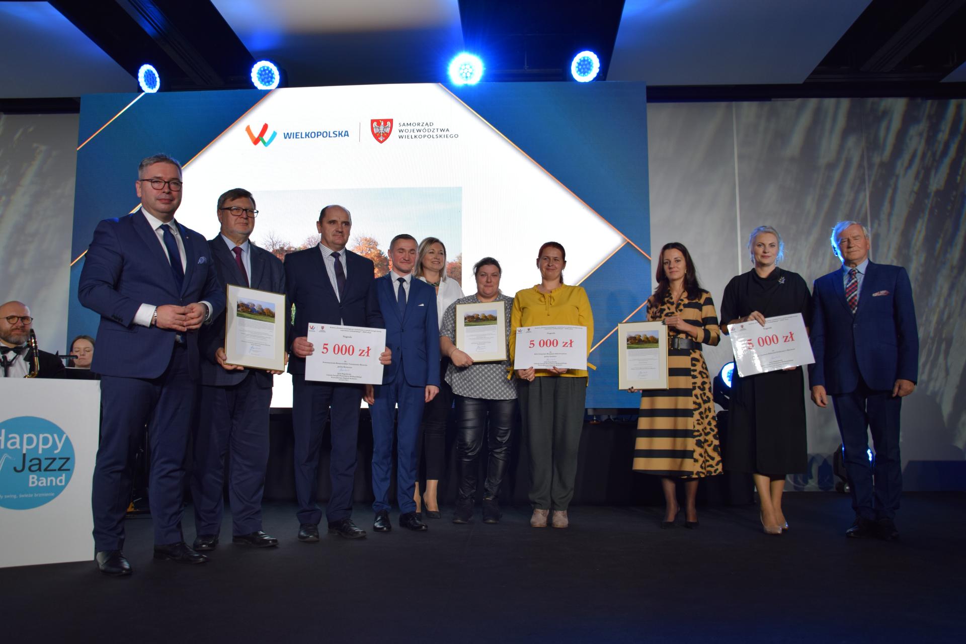 Grupa ludzi stoi na scenie.