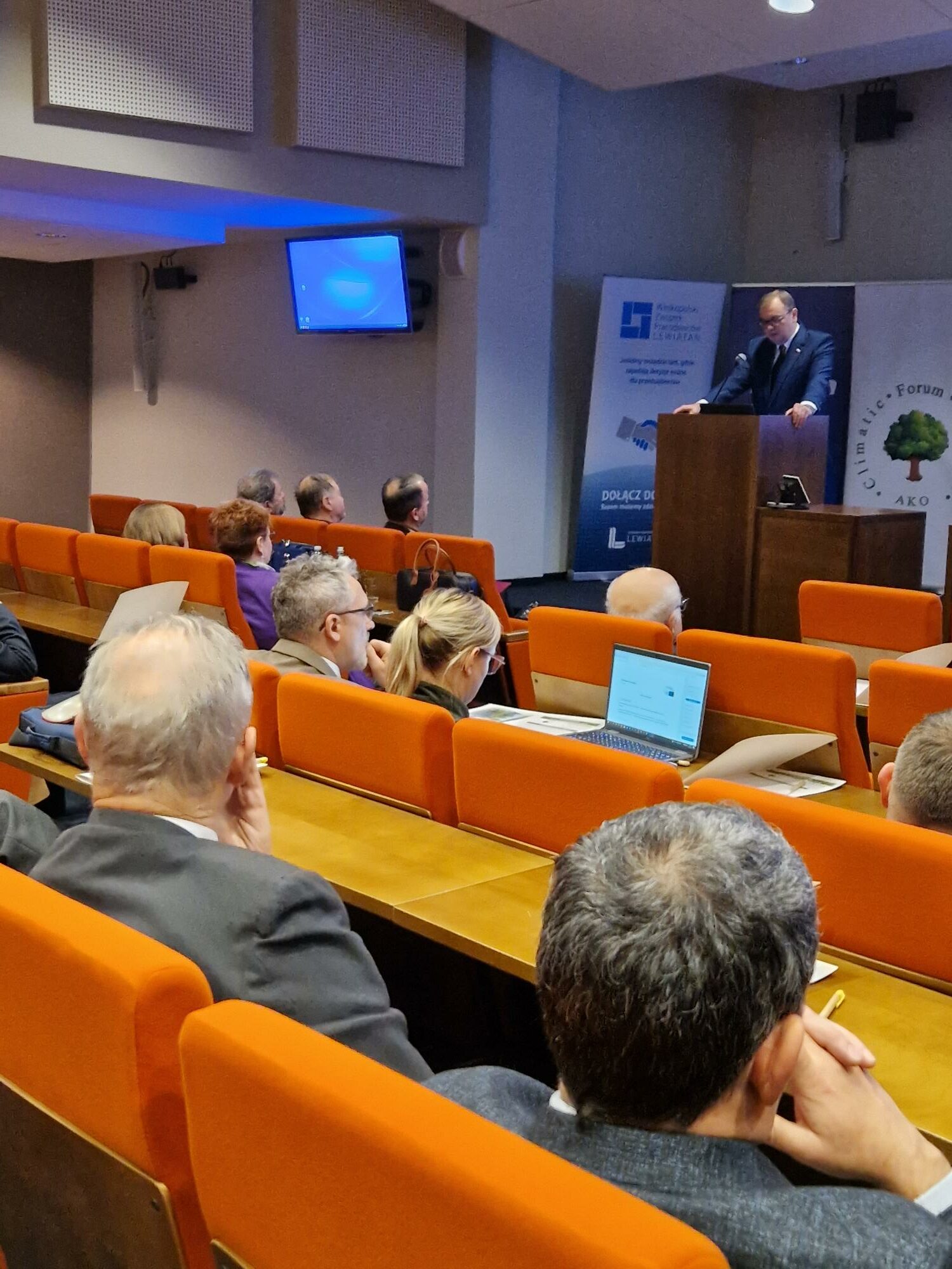 1 osoba stoi przy mównicy.