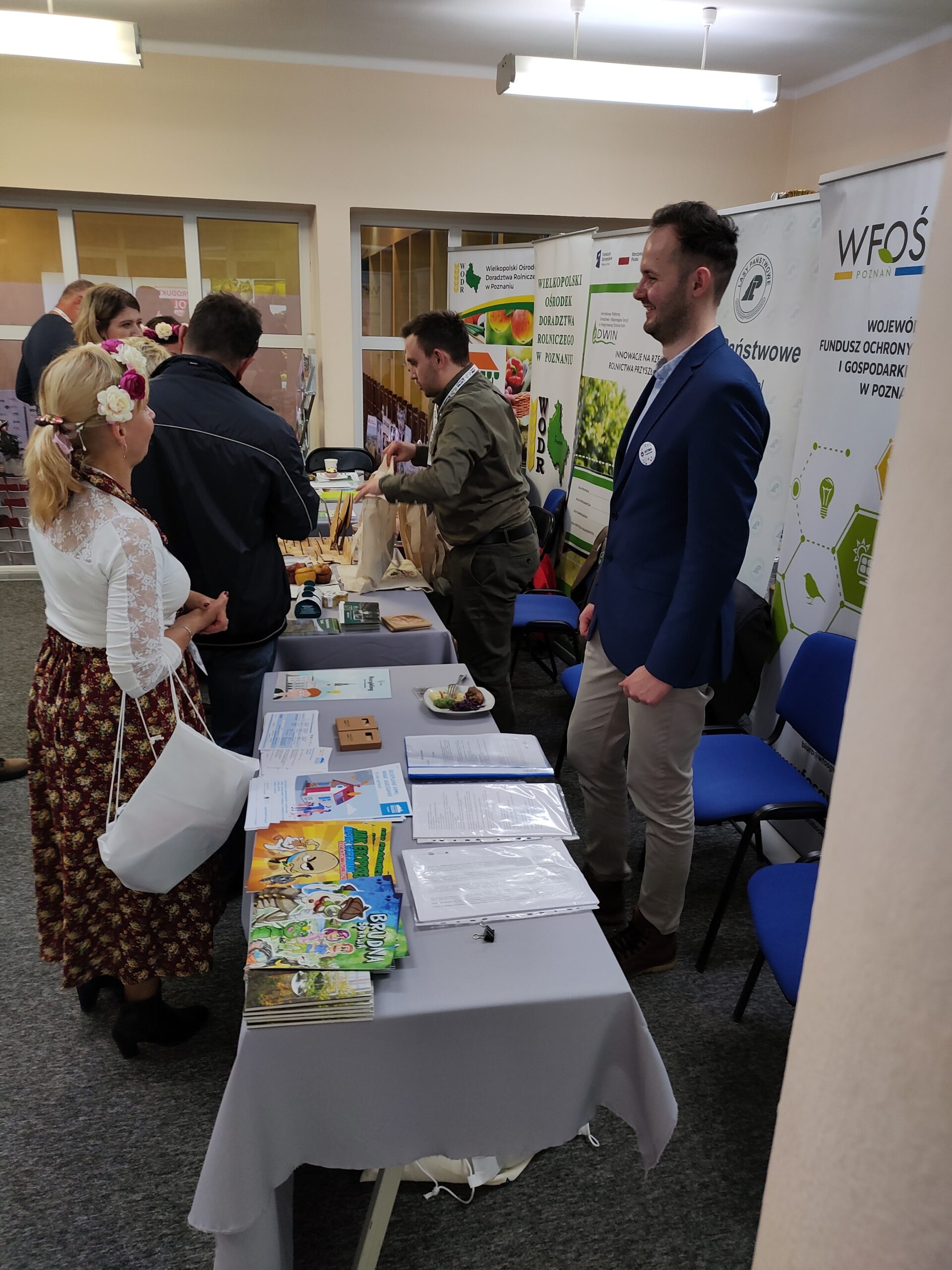 Ludzie przy stoisku wystawienniczym.