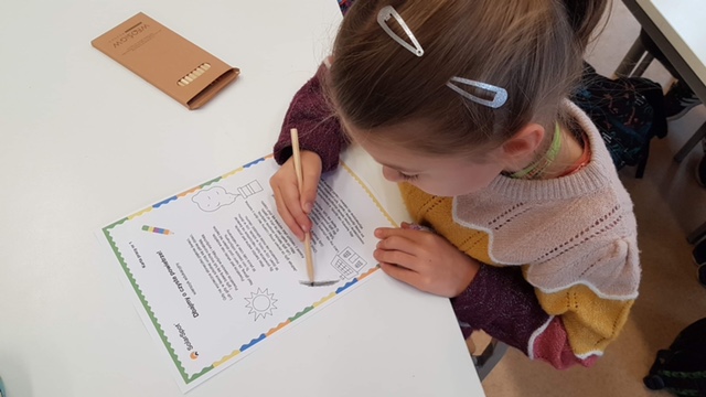 Dziewczynka koloruje kredkami.