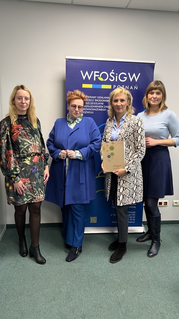 4 osoby stoją na tle ściany