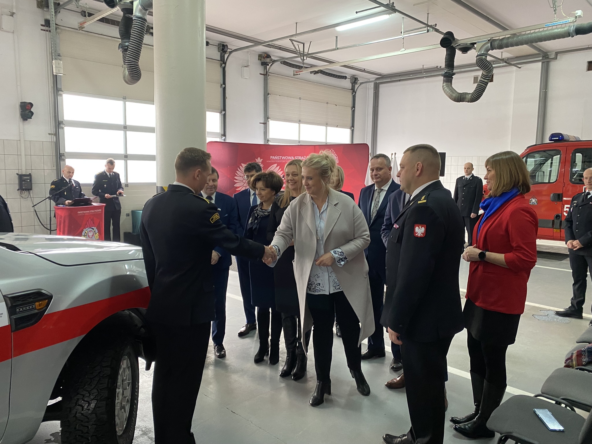 Na zdjęciu stoi grupka ludzi.