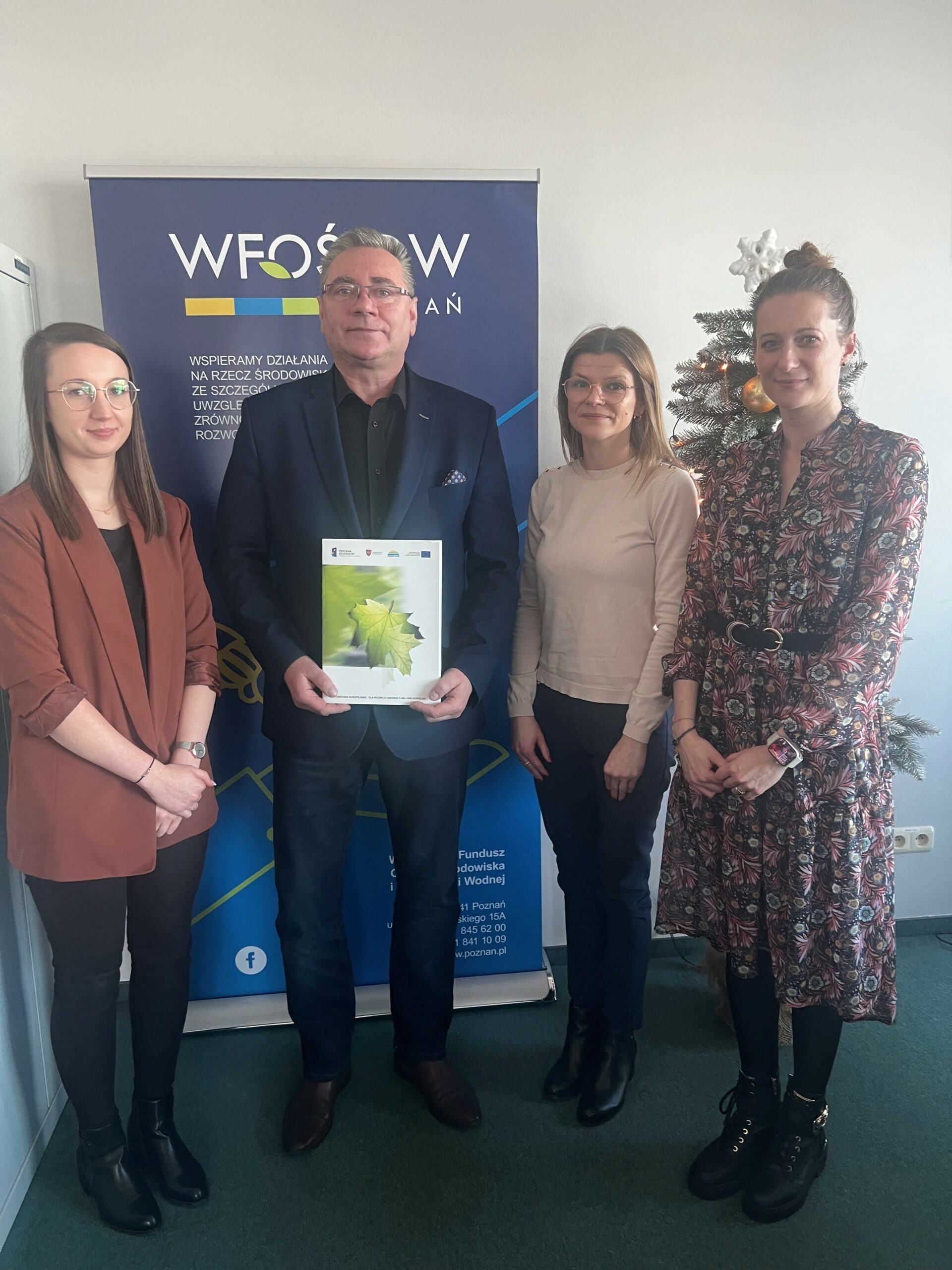 4 osoby stoją na tle ściany