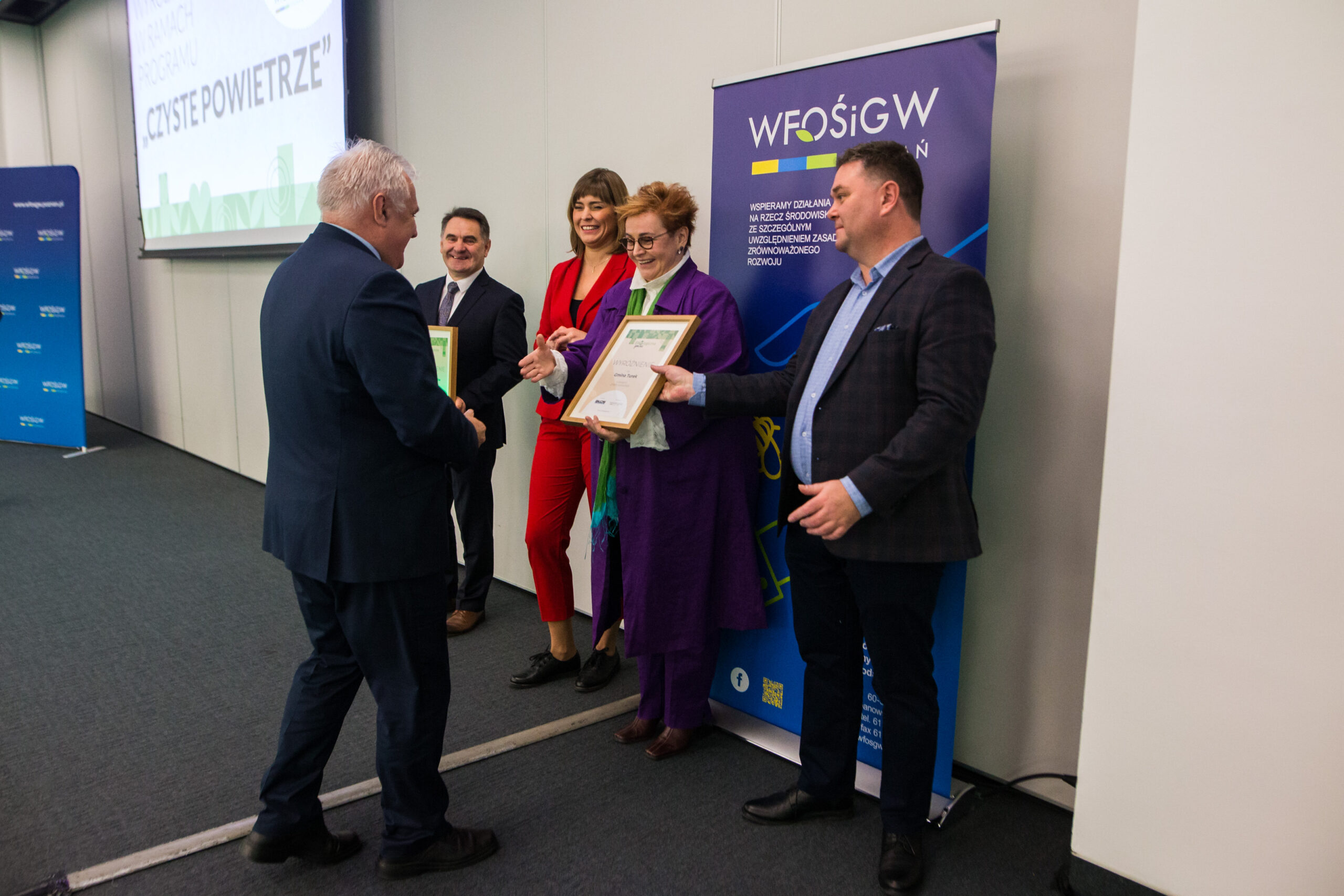 5 osób stoi na tle ściany