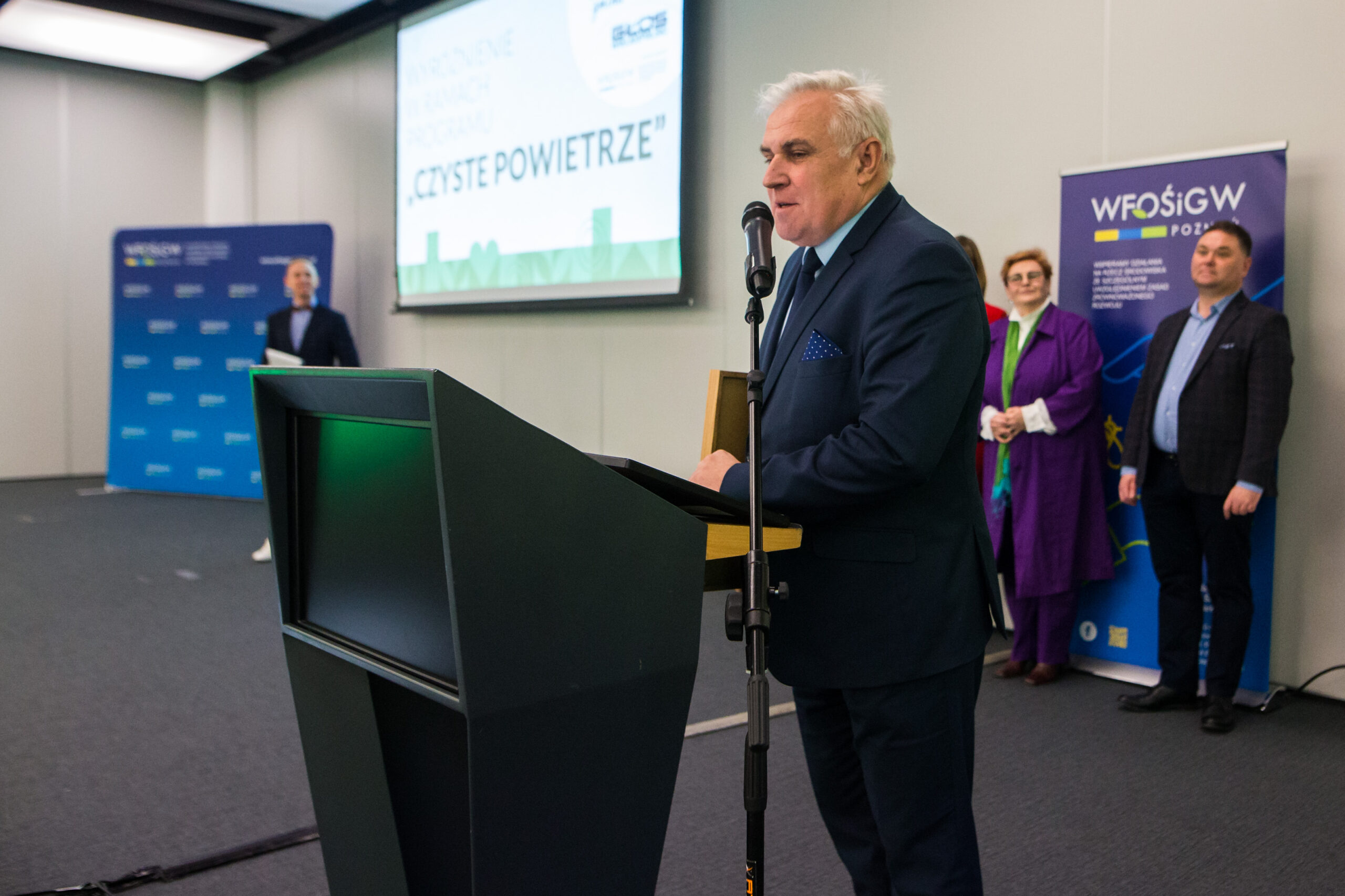 1 osoba stoi przy mównicy.