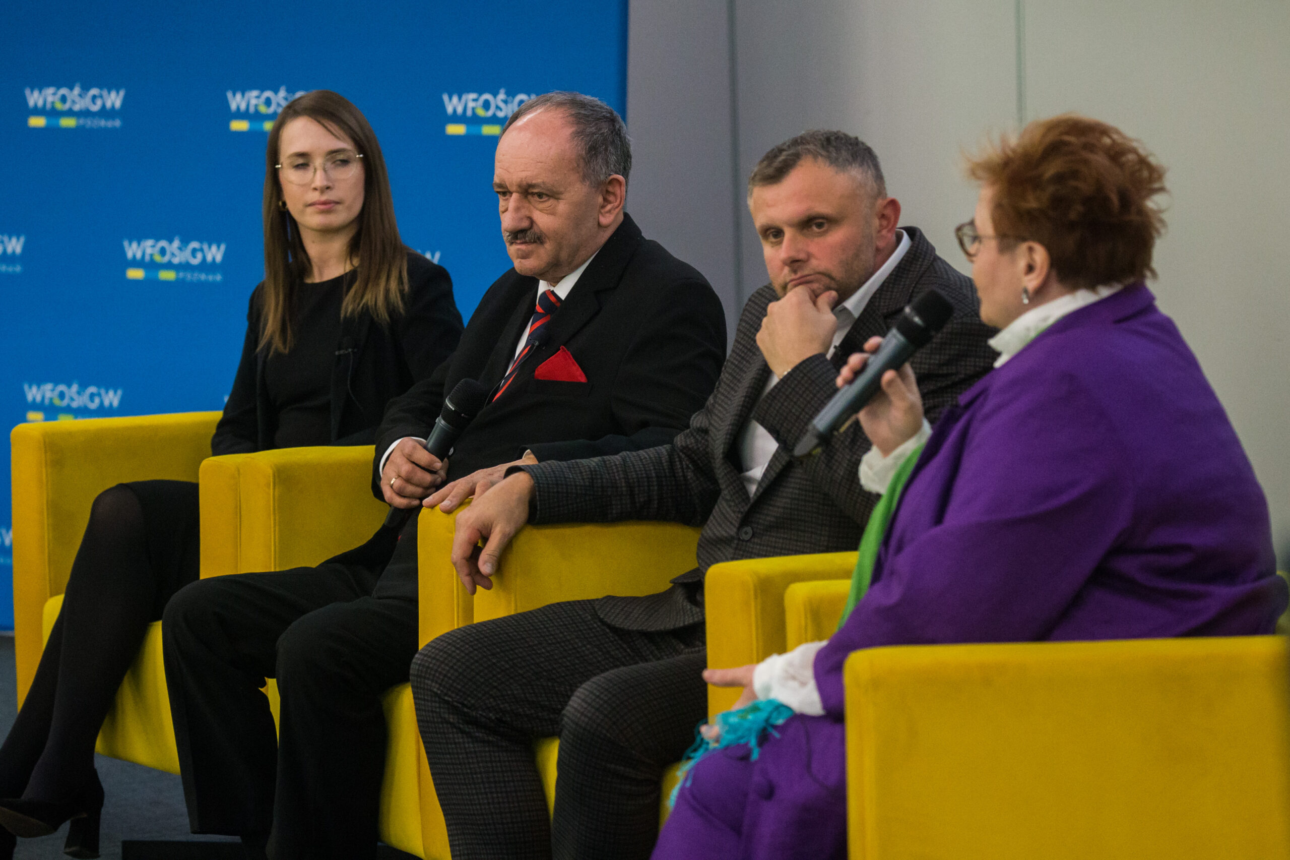 4 osoby siedzą na fotelach.