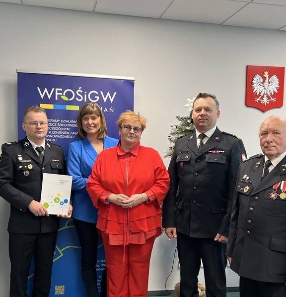 Na zdjęciu stoi 5 osób na tle bannera reklamowego.