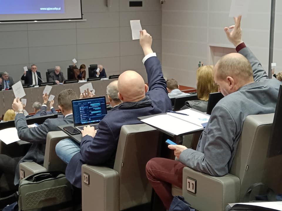 Widok sali konferencyjnej pełnej ludzi siedzących na krzesłach.