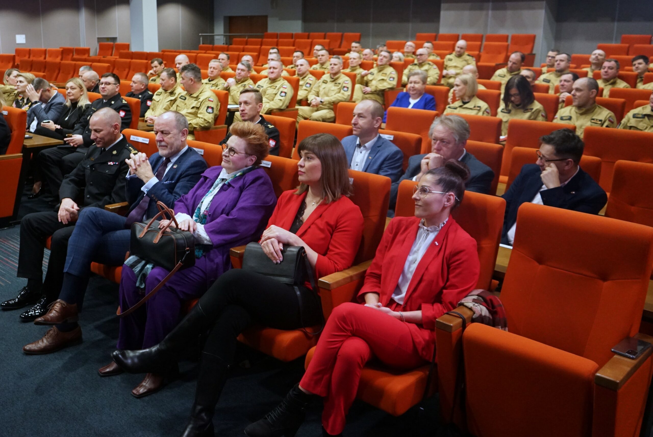 Sala wypełniona ludźmi siedzącymi na krzesłach.