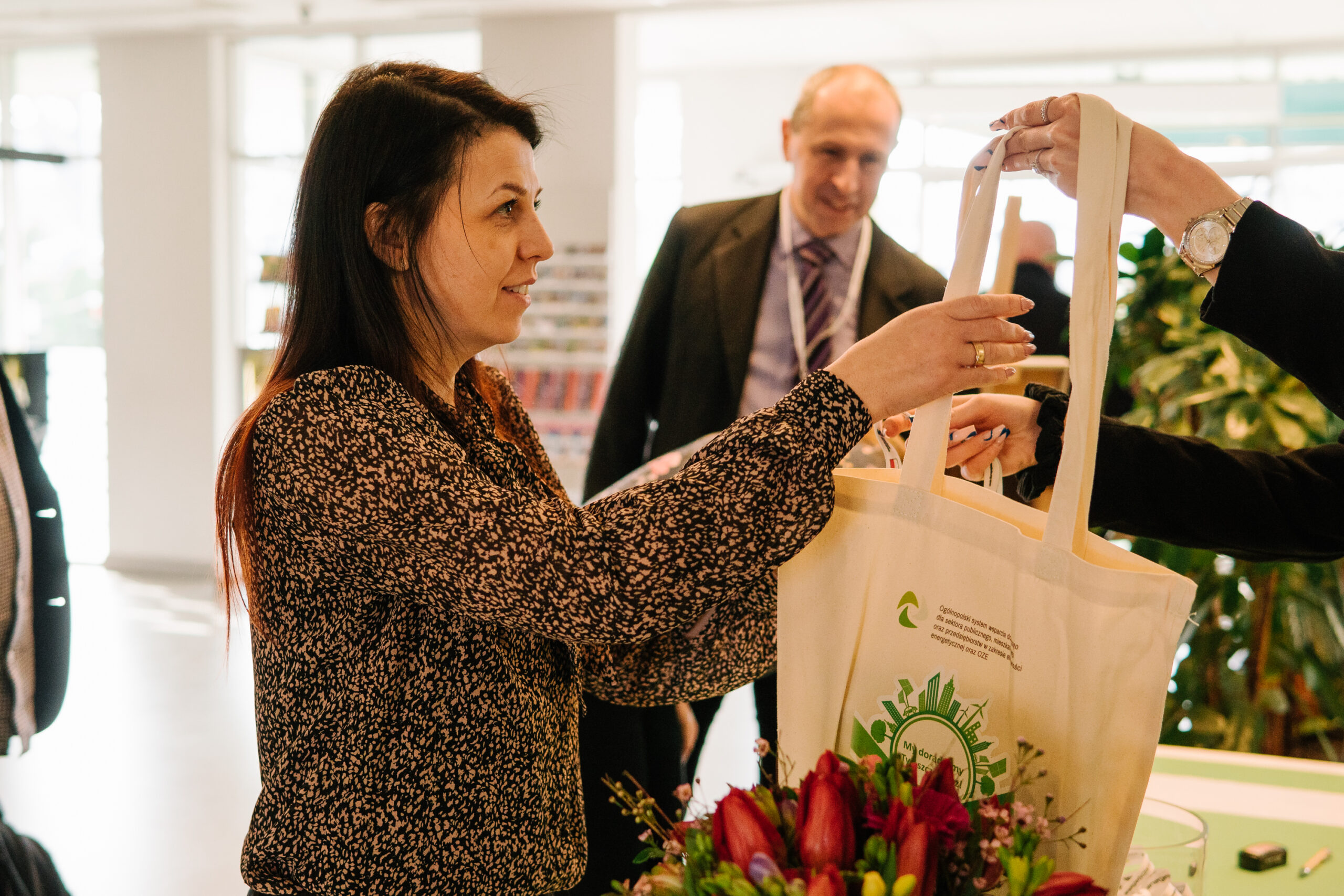 Osoba odbierająca torbę z materiałami na konferencję.