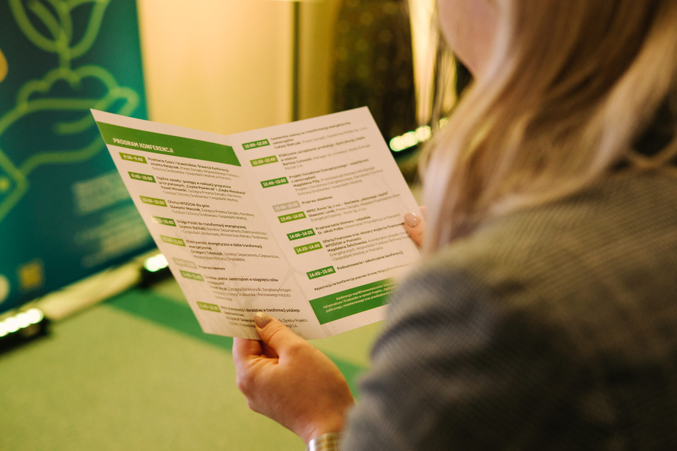 1 osoba czyta program konferencji.