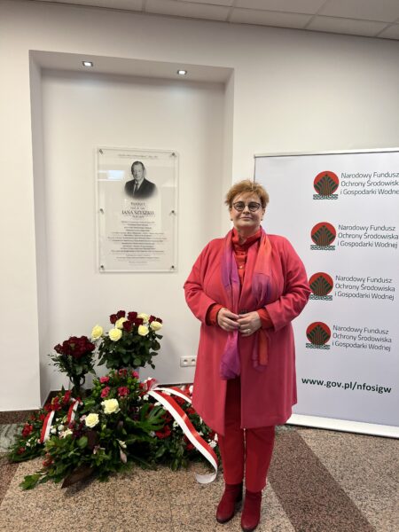 Prezes Zarządu WFOŚiGW w Poznaniu na tle tablicy upamiętniającej śp. Profesora Jana Szyszko.