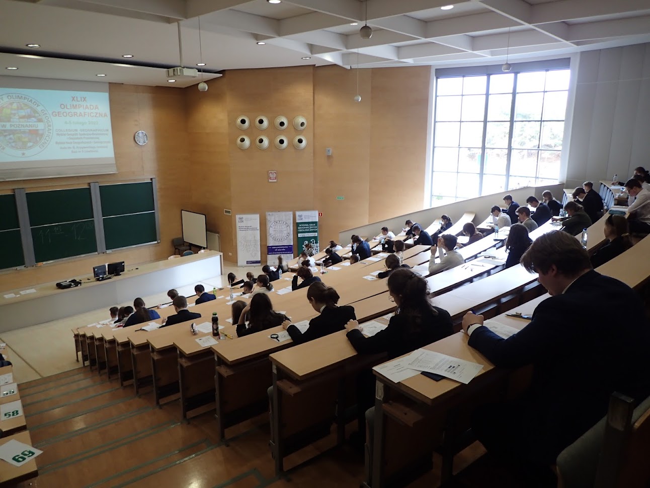 Sala wykładowa, a na niej siedzący studenci/uczniowie.