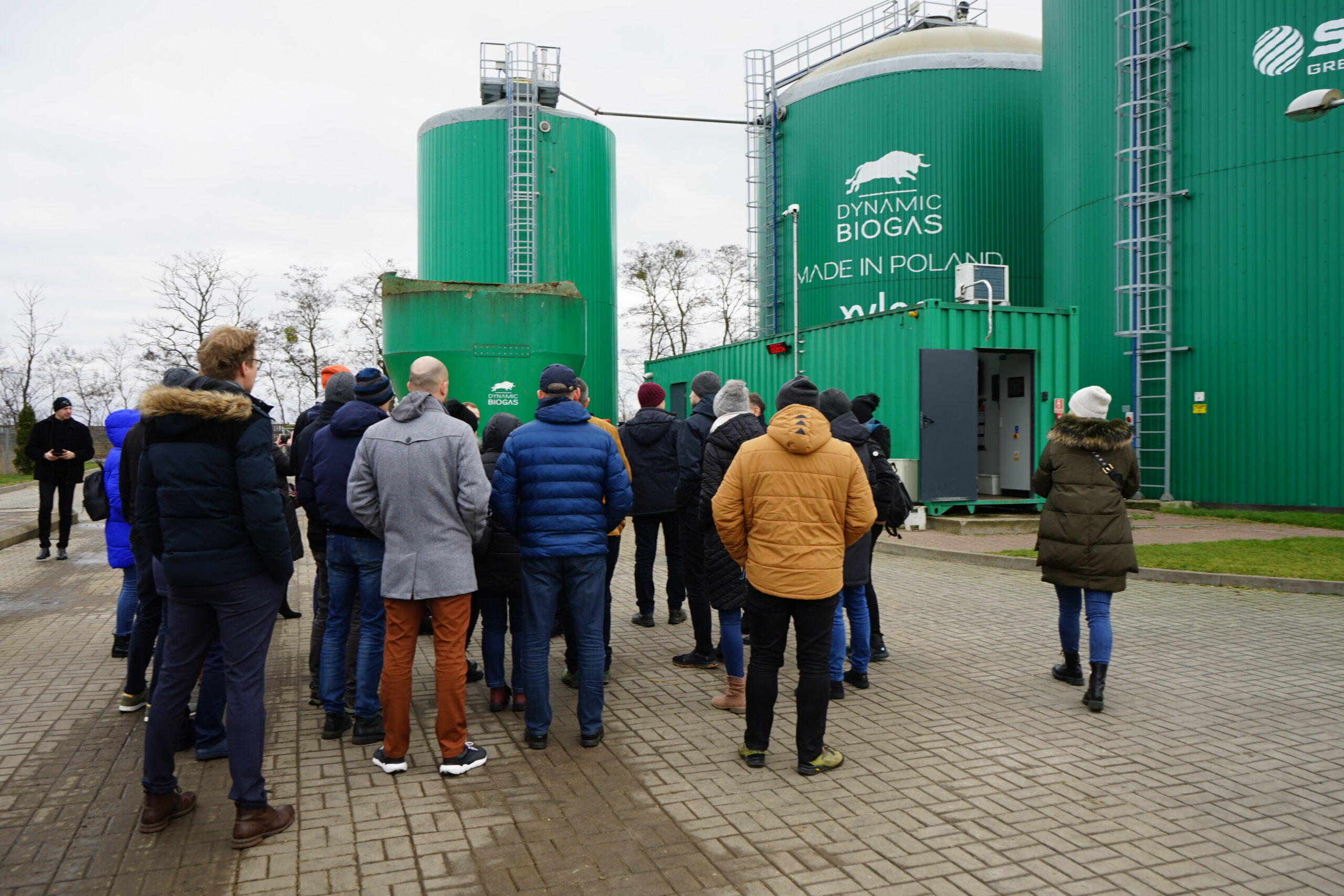 Ludzie idący po terenie biogazowni.