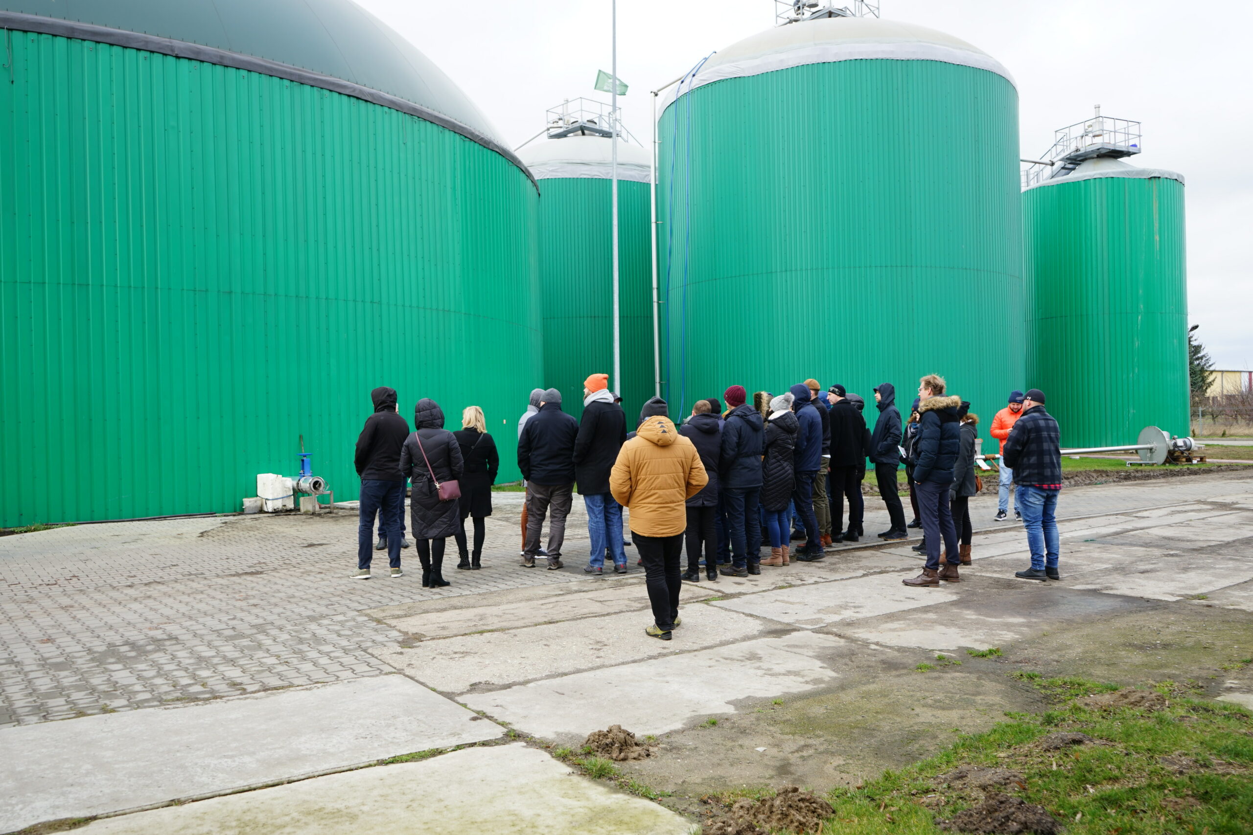Ludzie idący po terenie biogazowni.