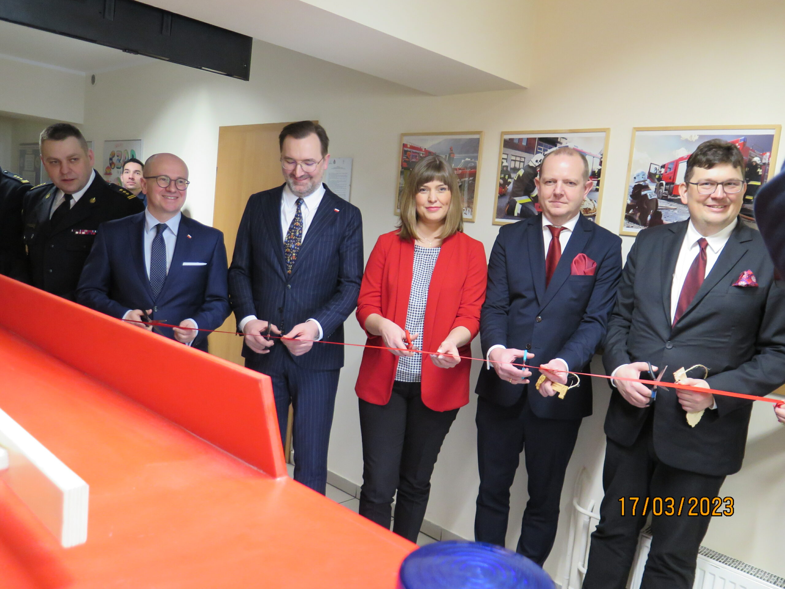 5 osób stoi i przecina wstęgę.