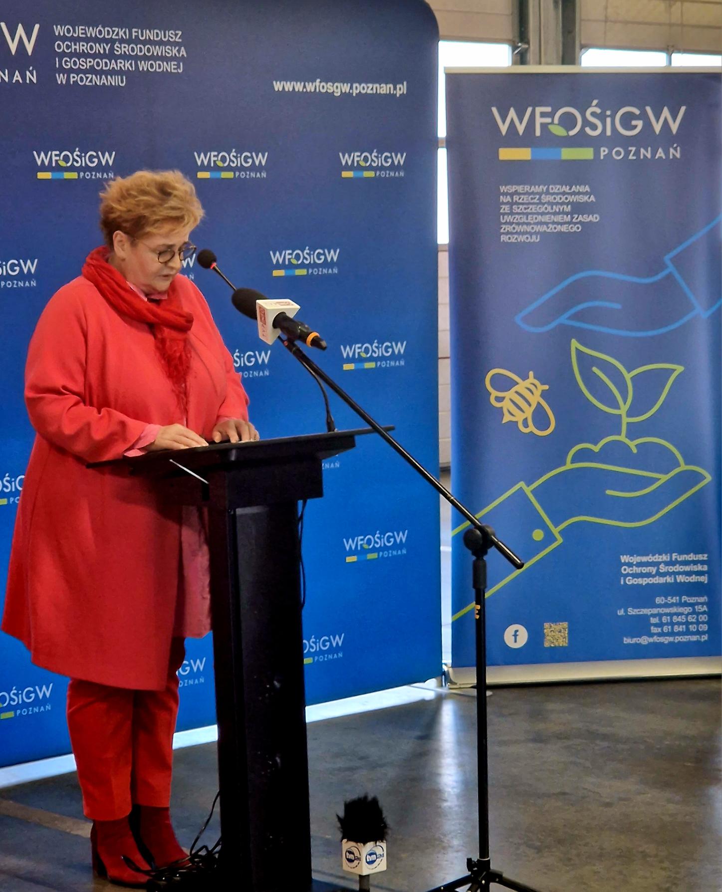 Jedna osoba stoi przy mównicy i przemawia.