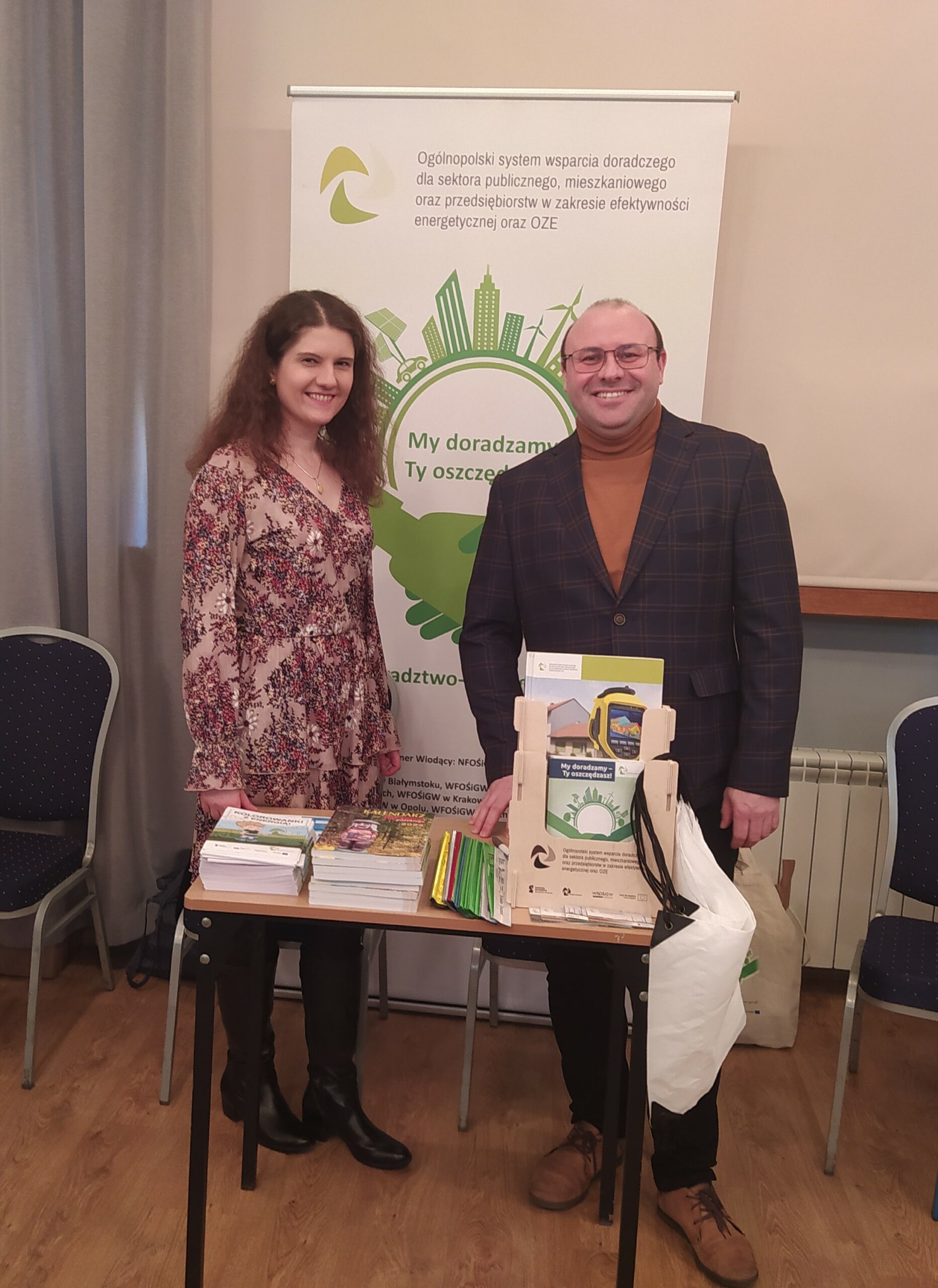 2 osoby stoją przy stoisku wystawienniczym