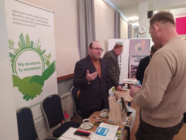 Stoisko wystawiennicze., a przy nim ludzie.