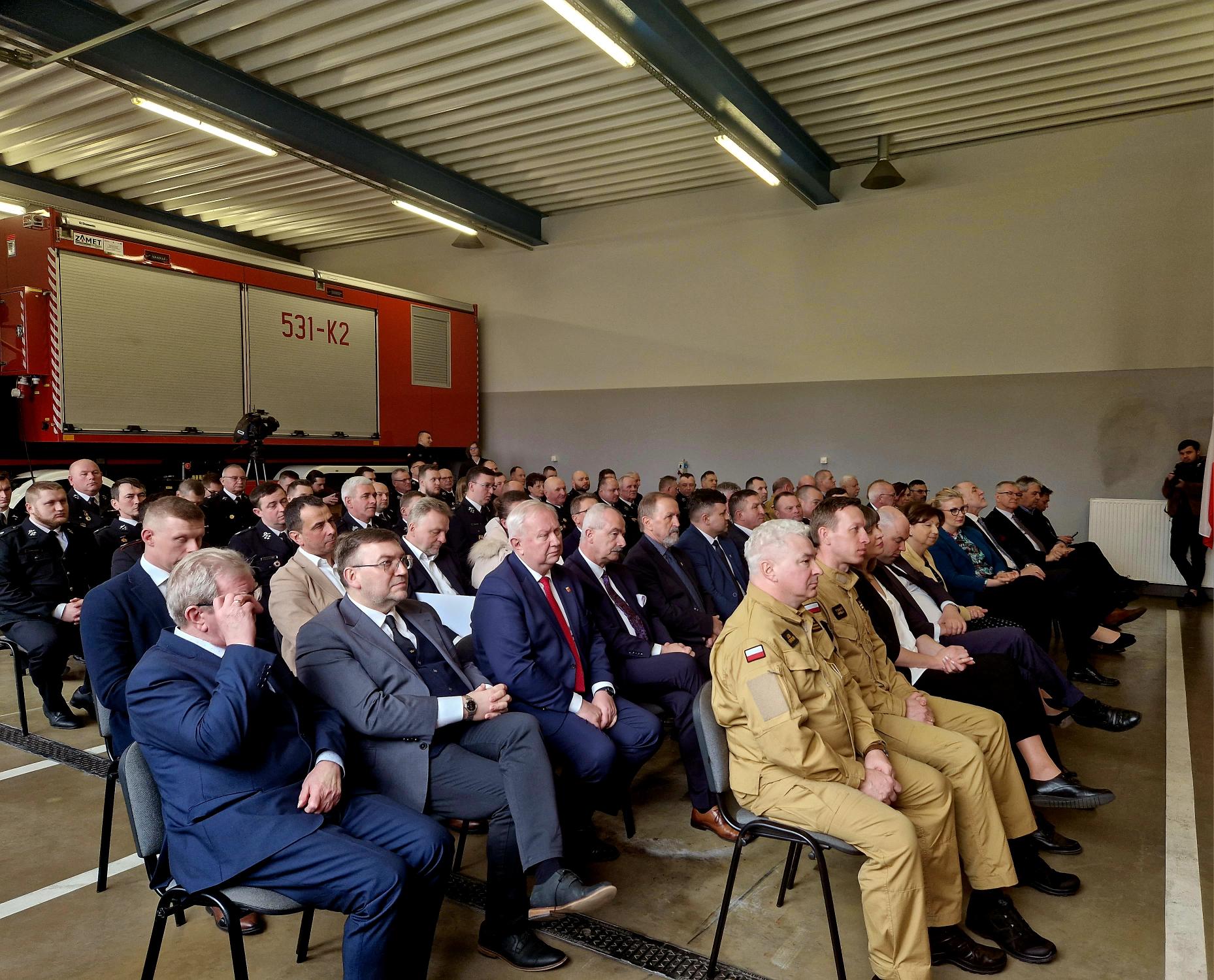 Duża grupa osób siedzi na krzesłach na sali.