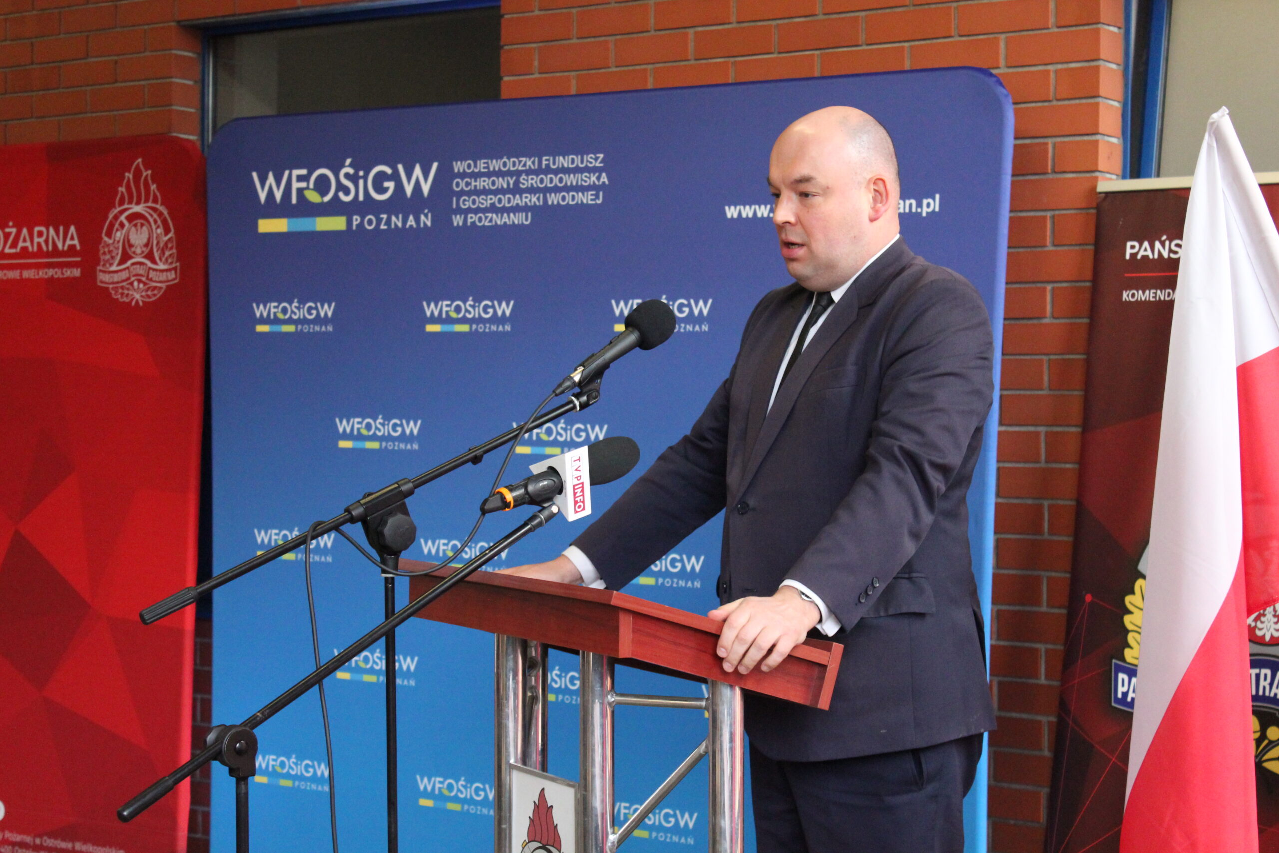 Jedna osoba stoi przy mównicy i przemawia.