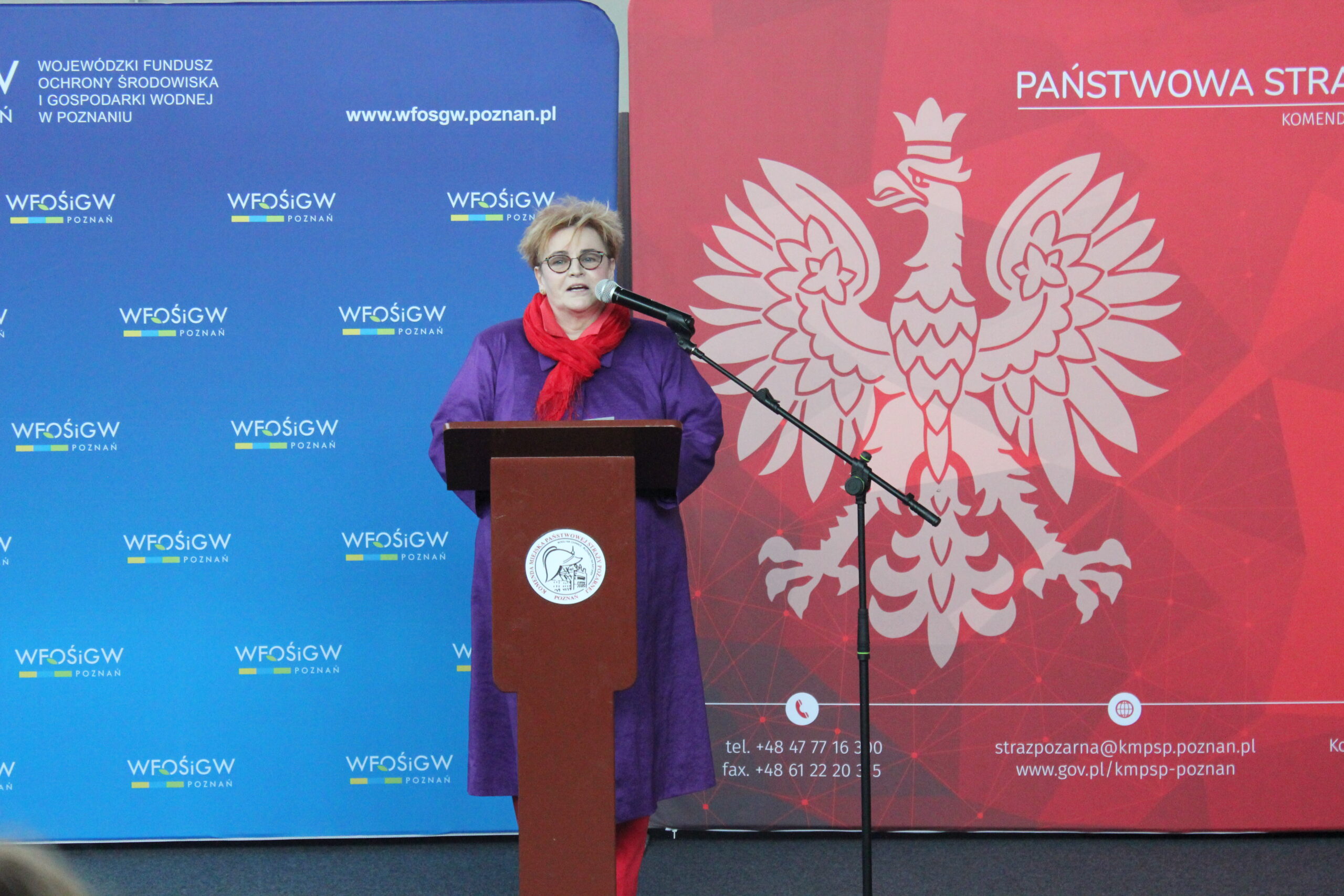 Jedna osoba stoi przy mównicy i przemawia.