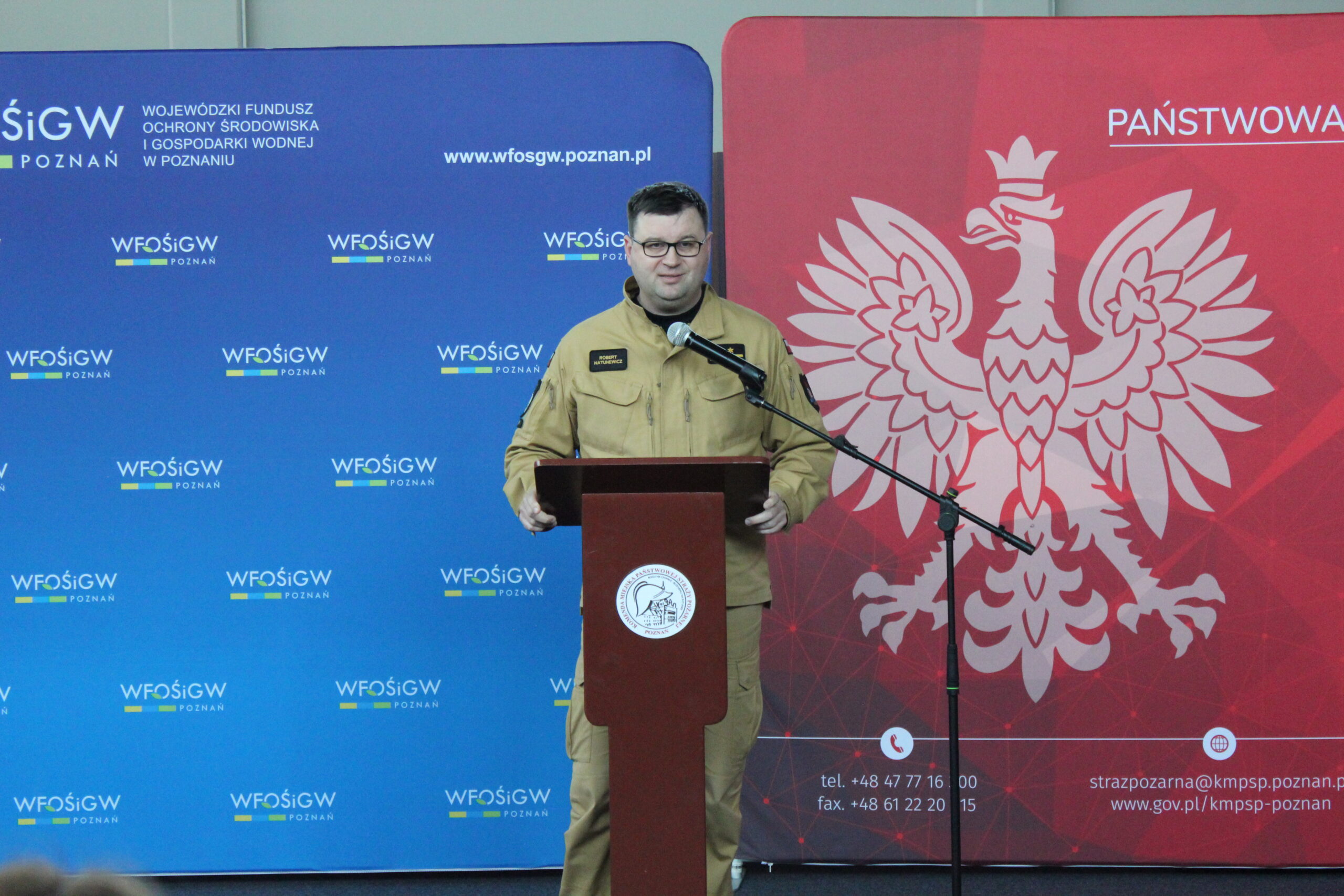 Jedna osoba stoi przy mównicy i przemawia.