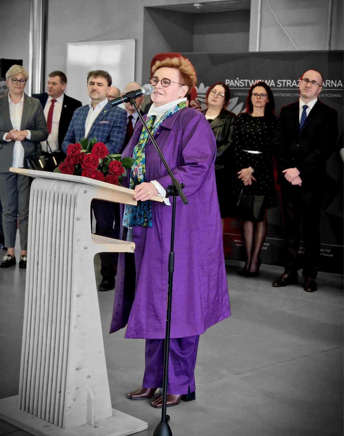 1 osoba stoi przy mównicy.