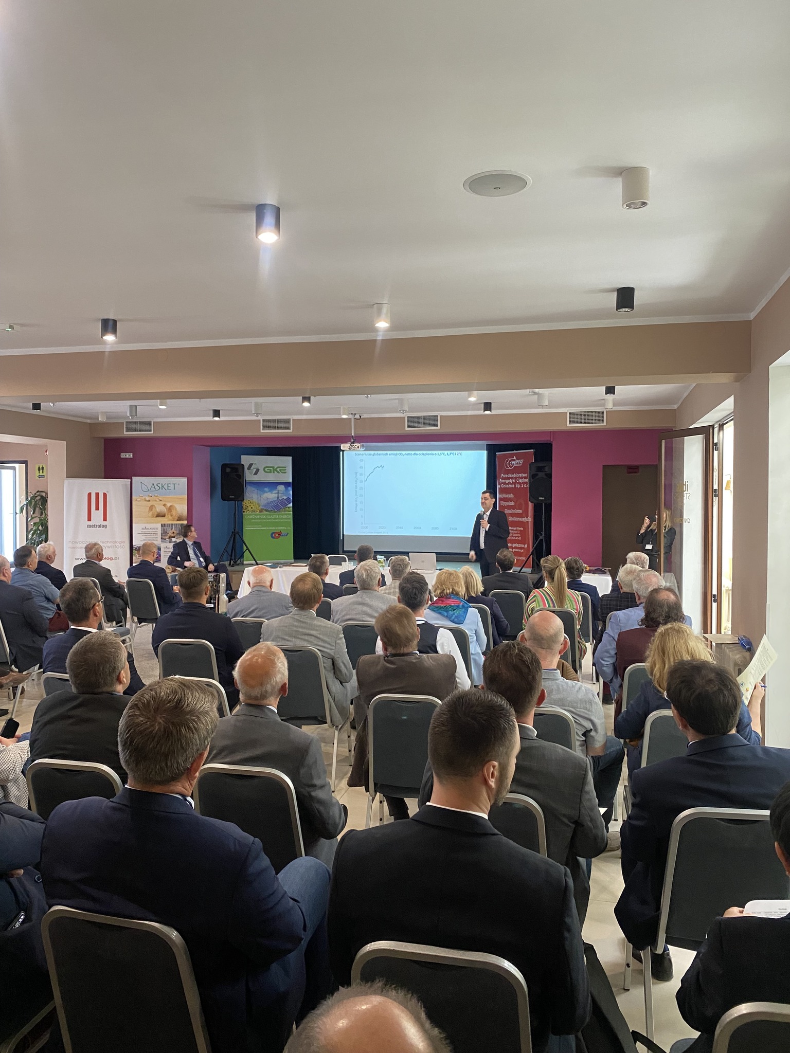 Widok na salę konferencyjną wypełnioną ludźmi siedzącymi na krzesłach