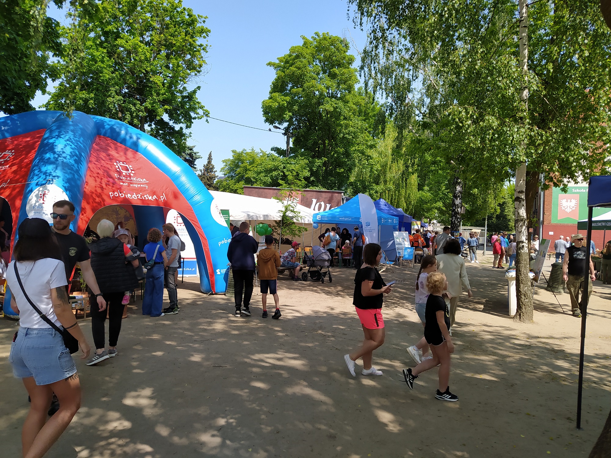 Dzieci podczas pikniku ekologicznego, w tle dmuchańce.