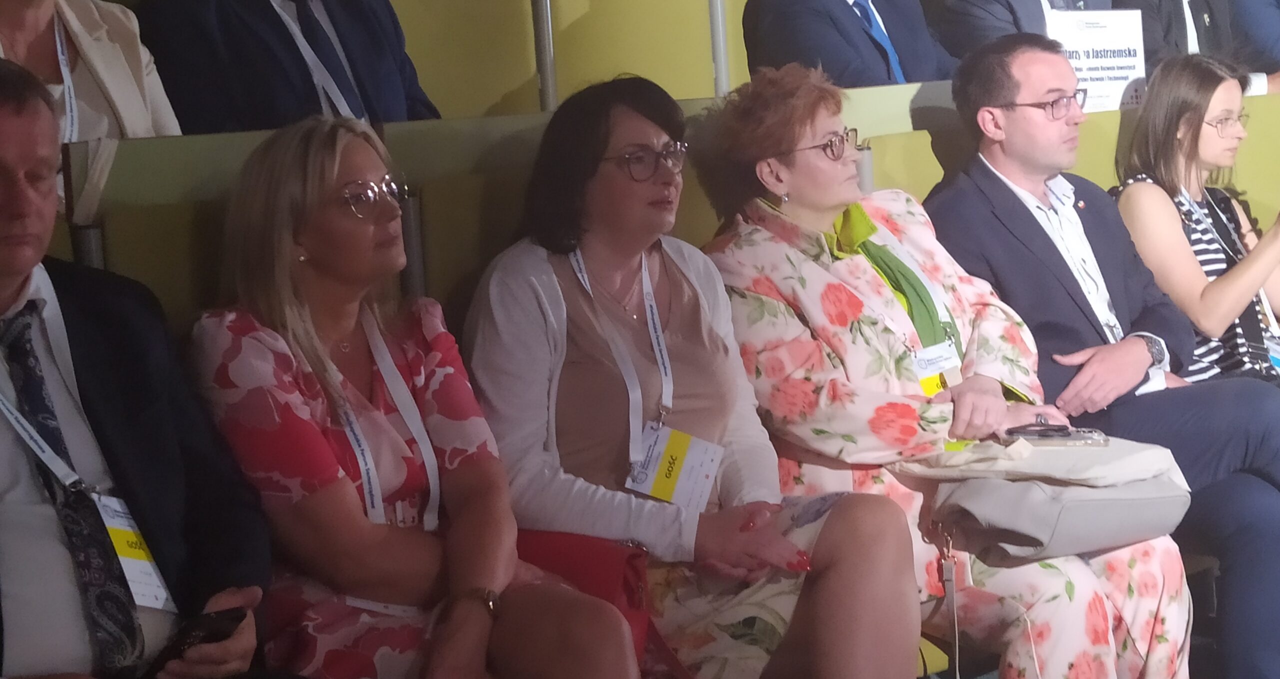 Osoby siedzą na sali