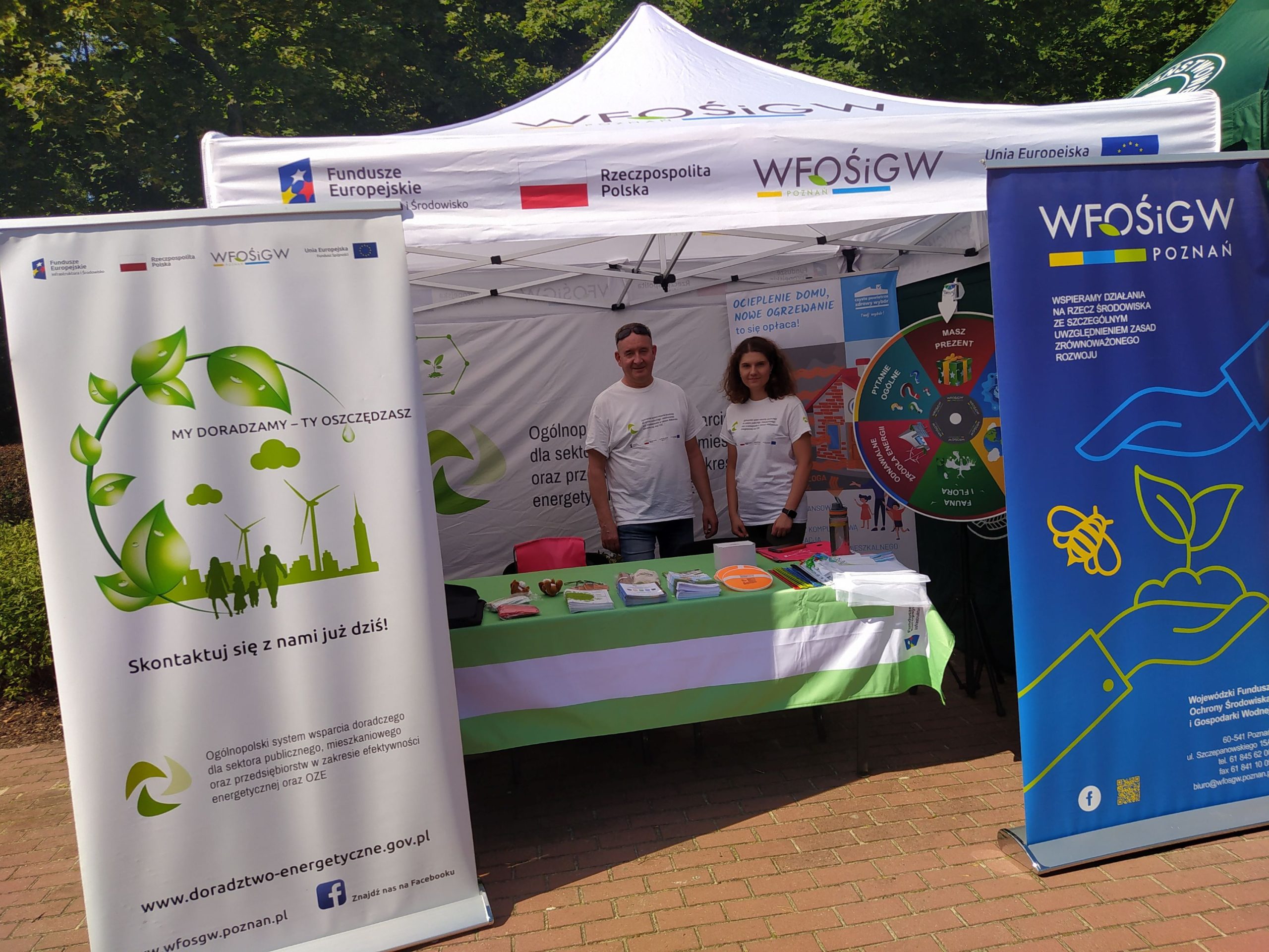 Stoisko WFOŚiGW w Poznaniu, na tle namiotu stoją dwie osoby