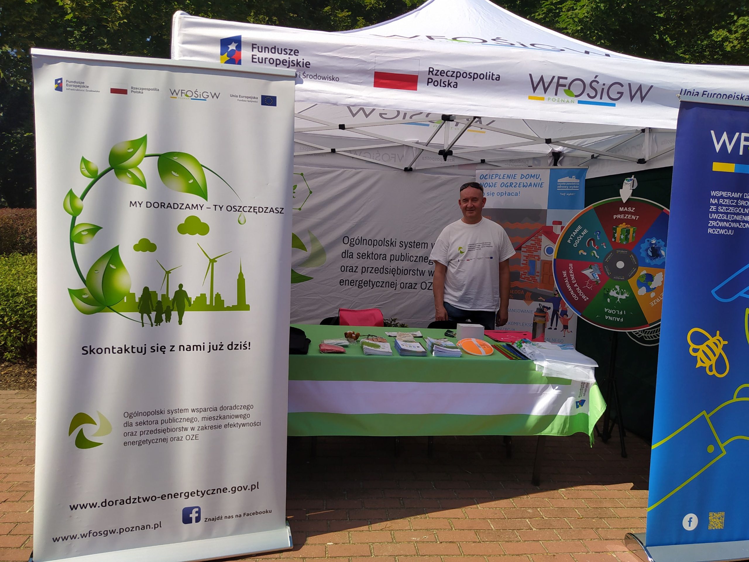 Stoisko WFOŚiGW w Poznaniu, na tle namiotu stoi jedna osoba