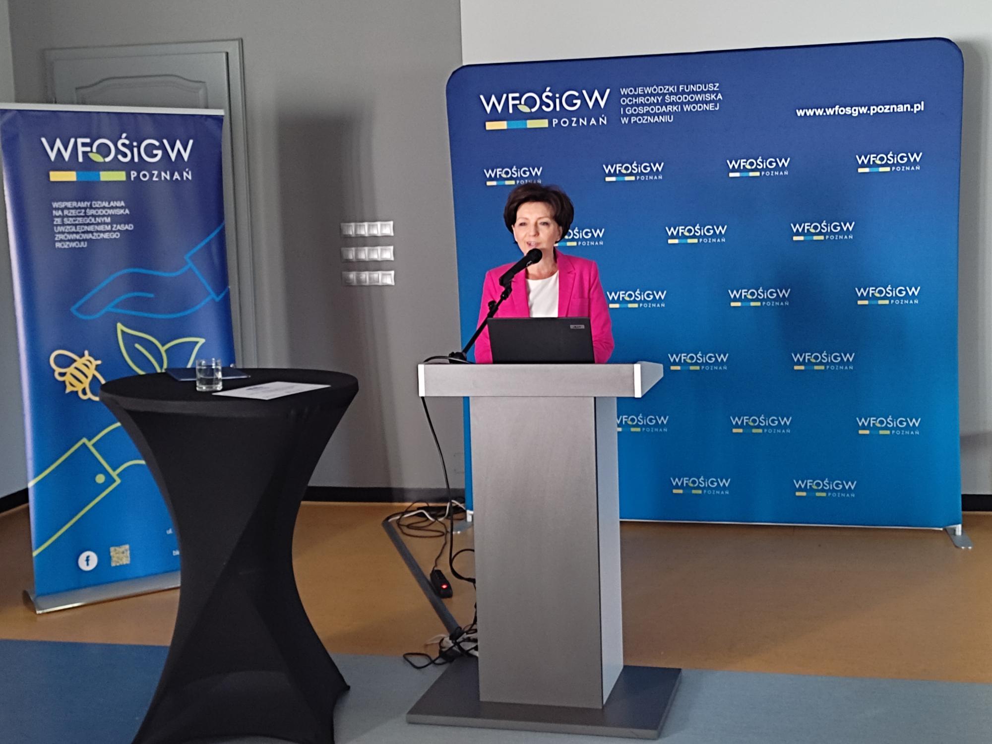 Jedna osoba stoi przy mównicy i przemawia.