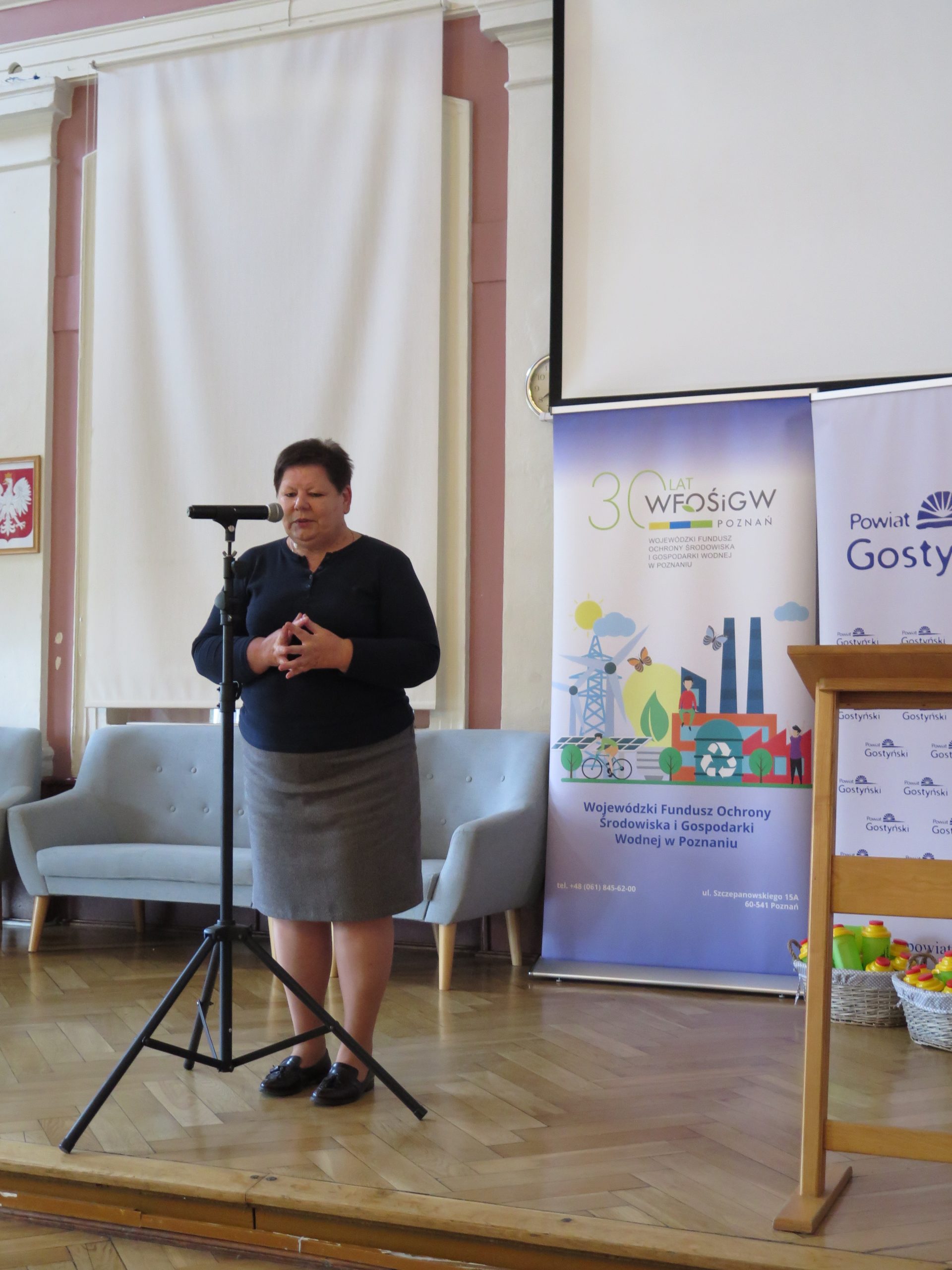 Jedna osoba stoi na scenie i przemawia.