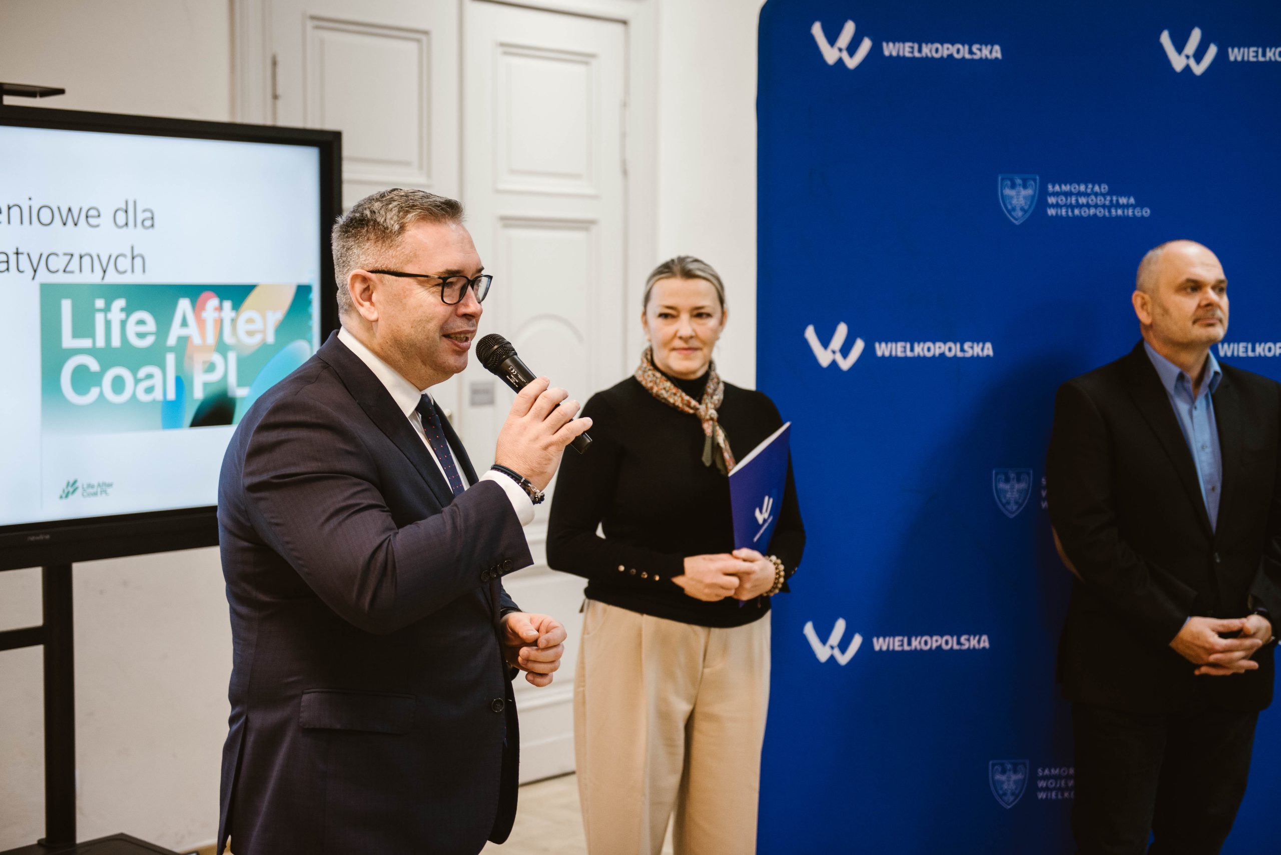 2 osoby stoją na środku sali i przemawiają