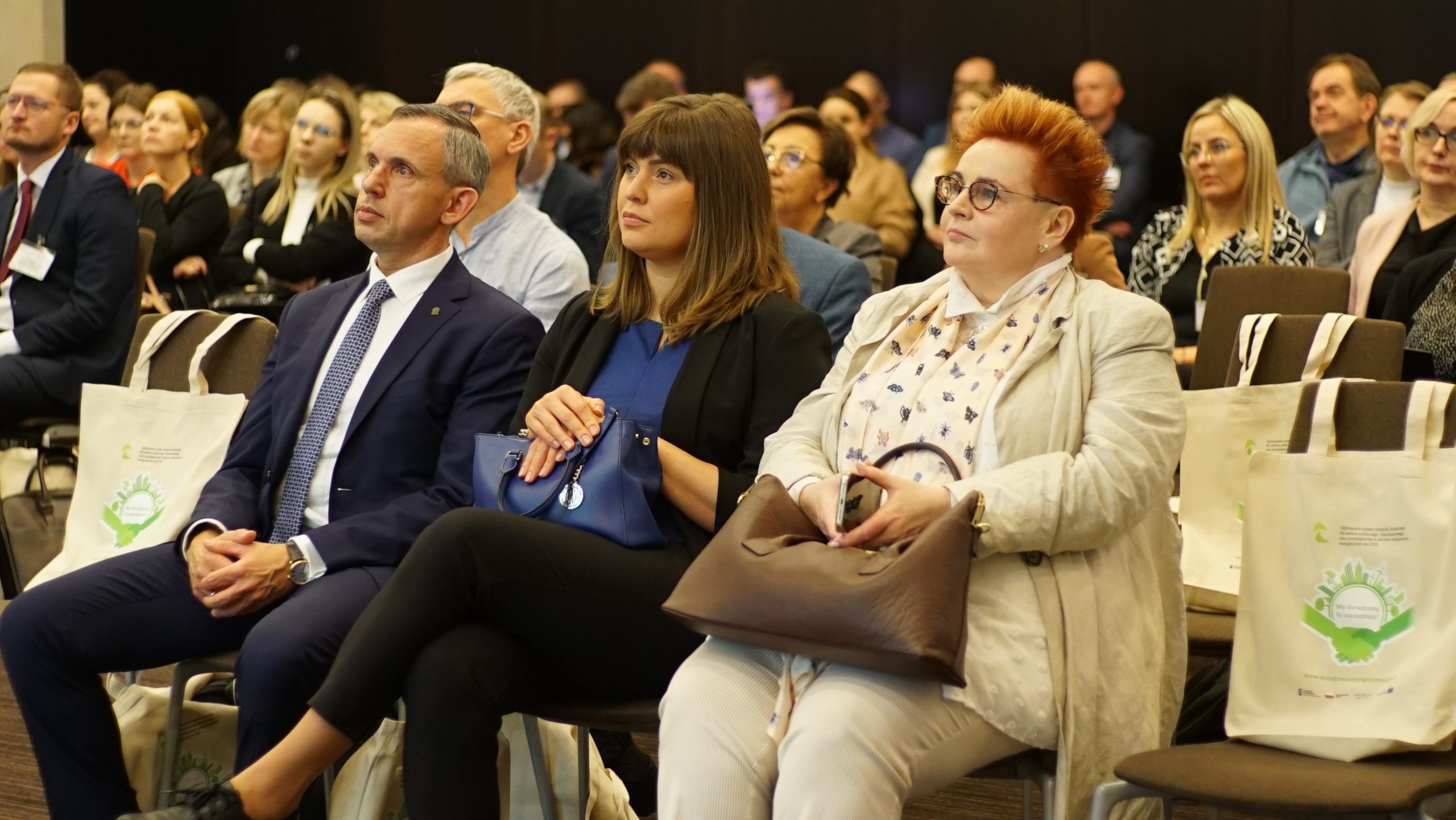 uczestnicy konferencji siedzą i słuchają.