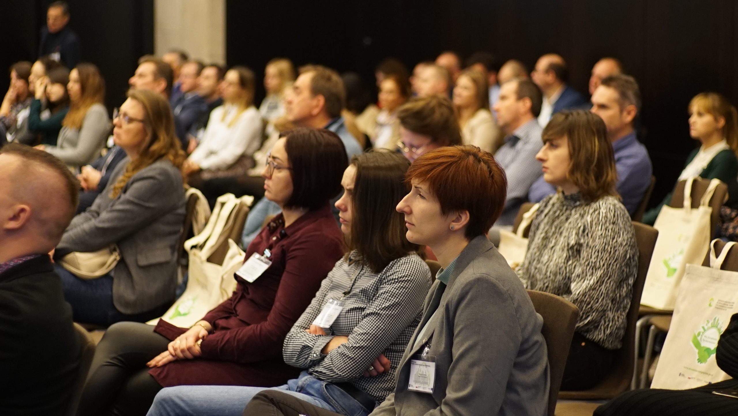 uczestnicy konferencji siedzą i słuchają.