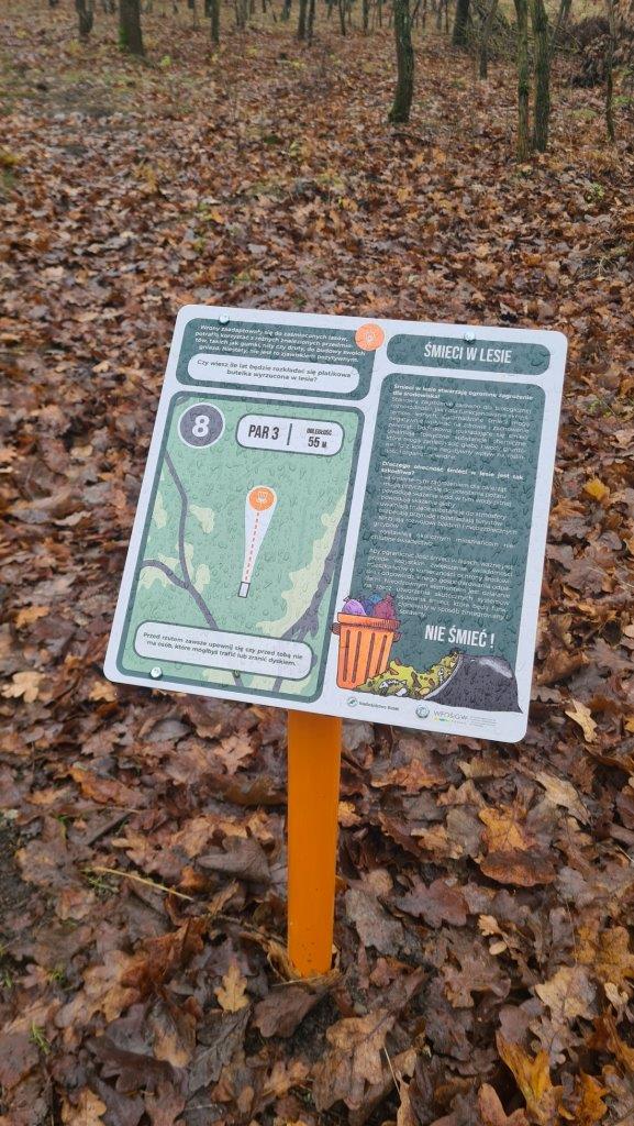 Tabliczka edukacyjna o nieśmieceniu w lesie na ścieżce edukacyjnej z disc golfem