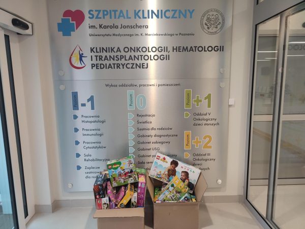 Na zdjęciu wejście do kliniki oraz kartony z zabawkami przywiezionymi dla dzieci przebywających w klinice.
