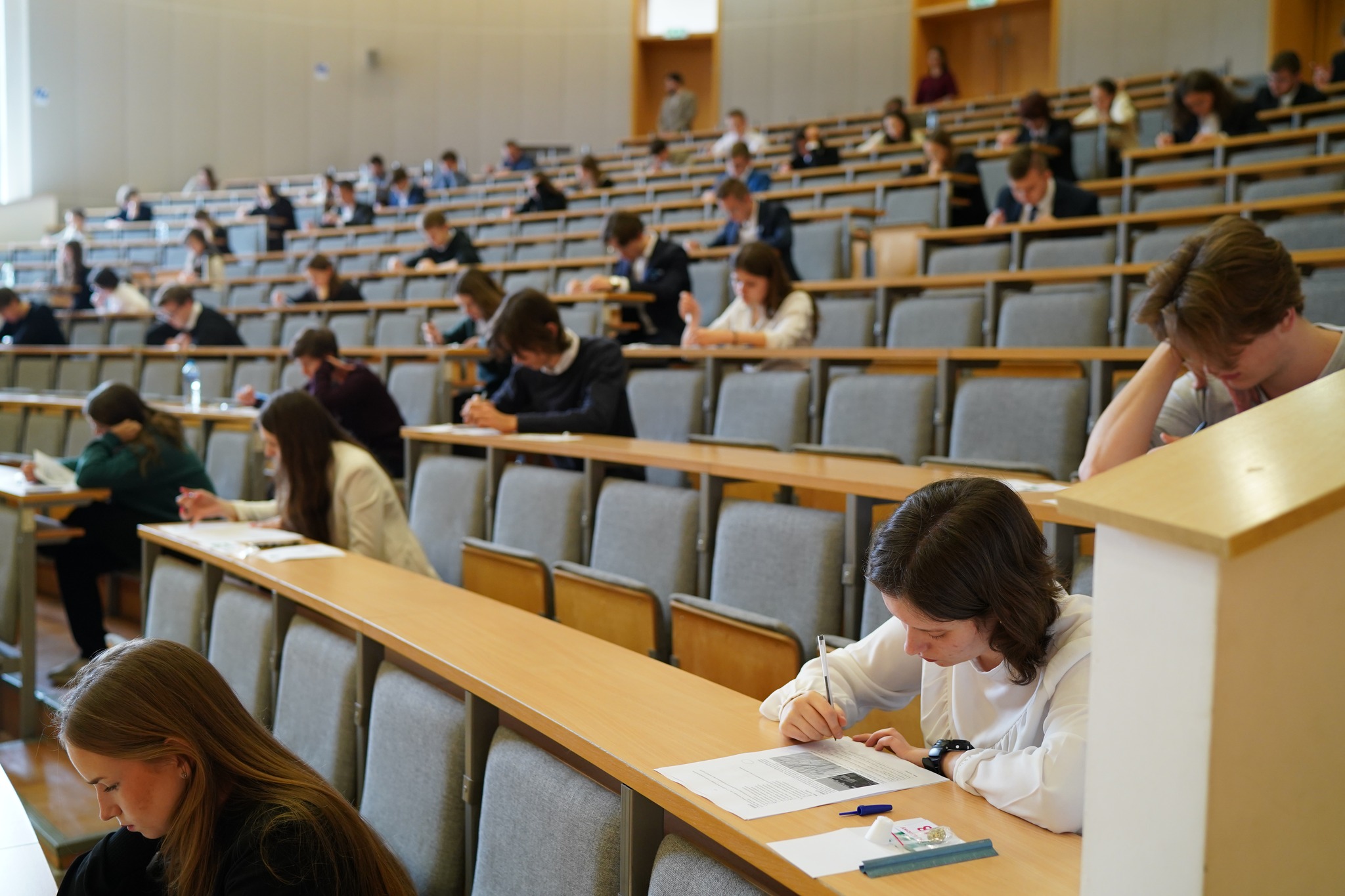 Widok na salę wykładową, na której siedzą uczestnicy olimpiady podczas rozwiązywania zadań.