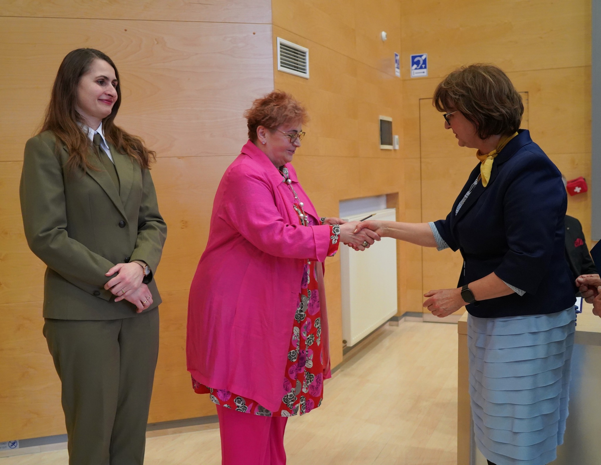 3 osoby stoją na scenie, w tym Pani Jolanta Ratajczak, Prezes Wojewódzkiego Funduszu Ochrony Środowiska i Gospodarki Wodnej w Poznaniu.