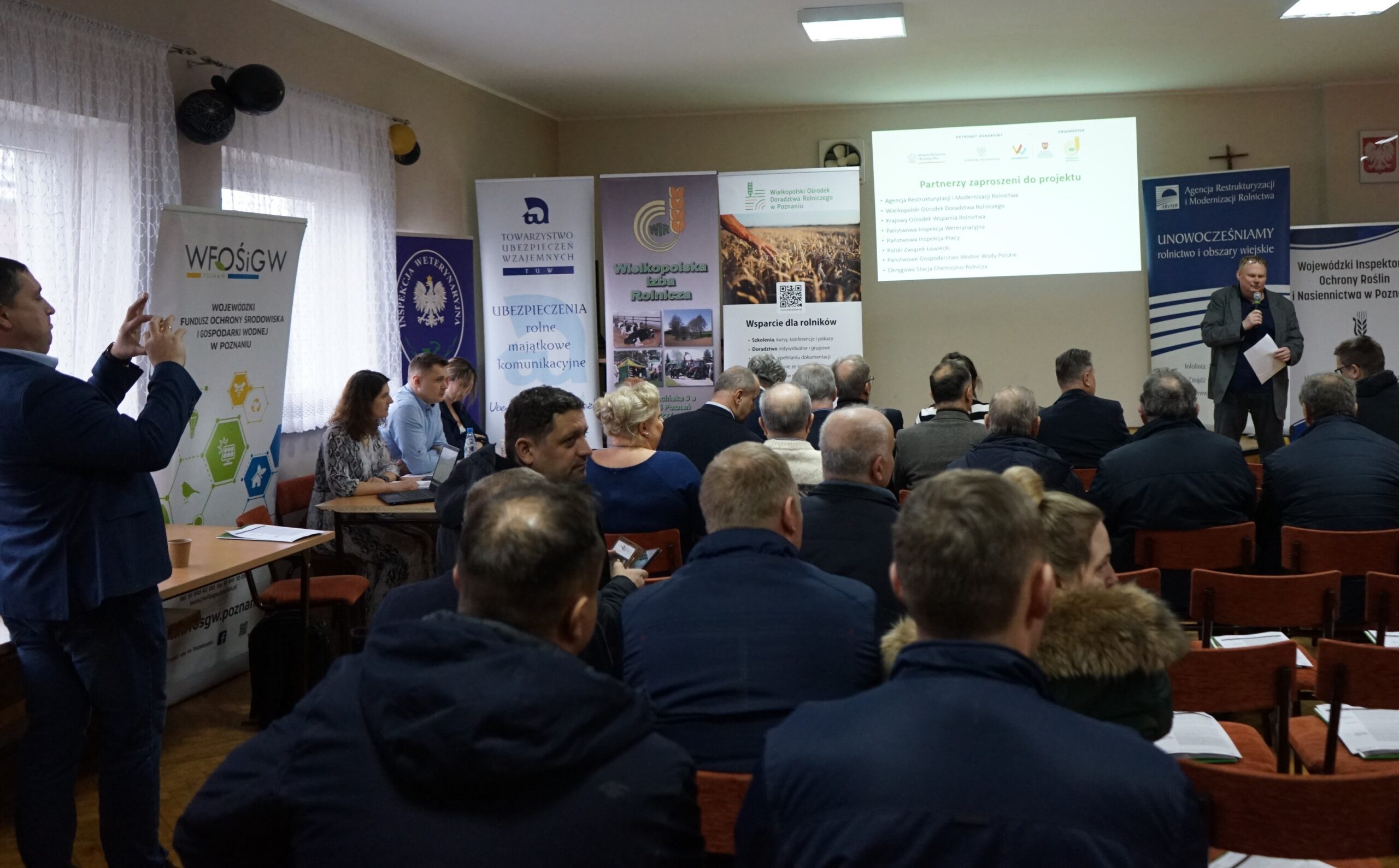 Widok na salę, w które odbywa się Forum Rolnicze 2024 powiatu wrzesińskiego - sala pełna ludzi siedzących na krzesłach.