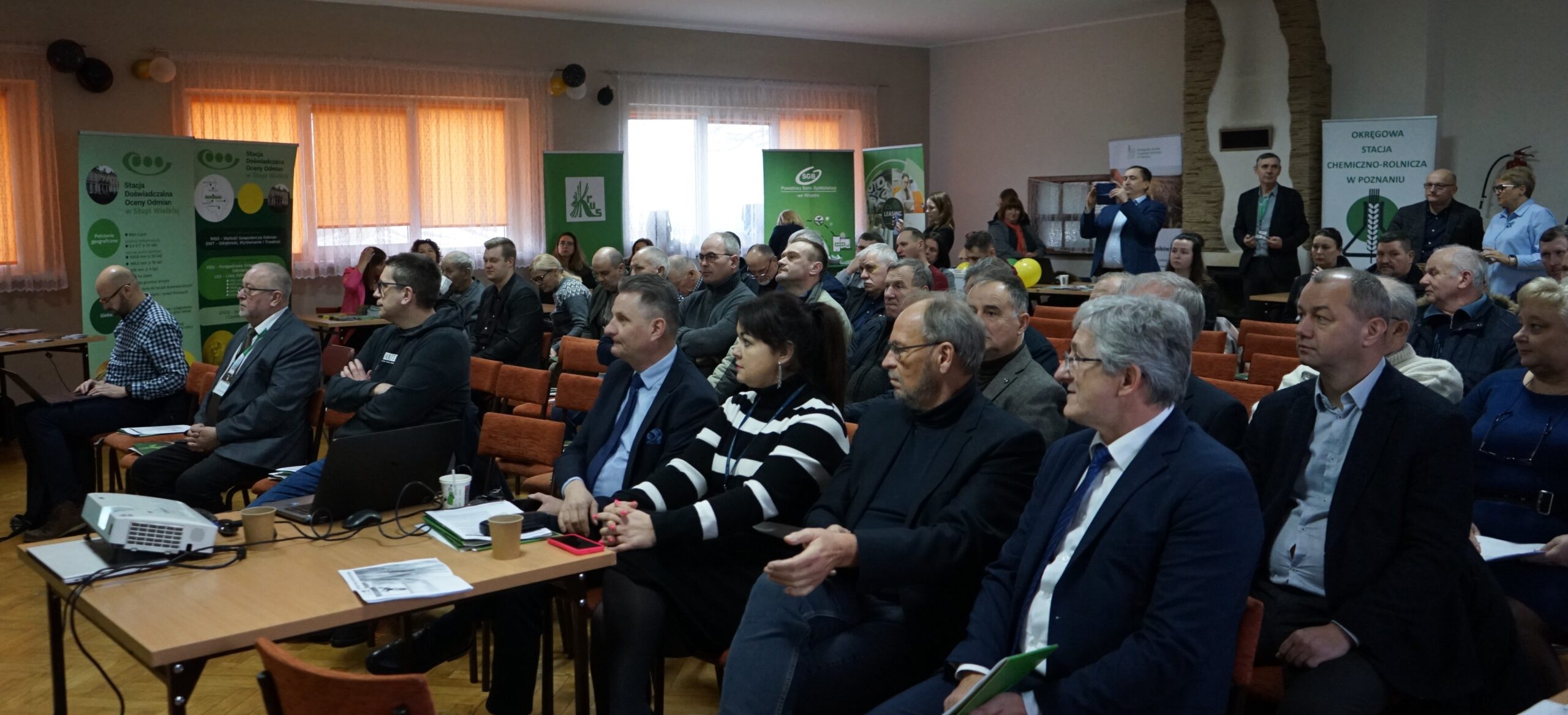 Widok na salę, w ktore odbywa się Forum Rolnicze 2024 powiatu wrzesińskiego - sala pełna ludzi siedzących na krzesłach.