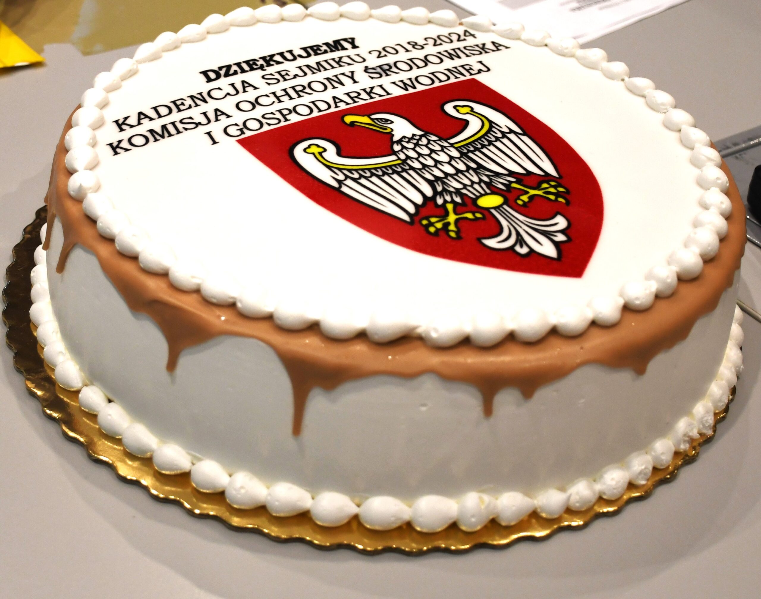 Tort z logotypem Komisji Ochrony Środowiska i Gospodarki Wodnej Sejmiku Województwa Wielkopolskiego