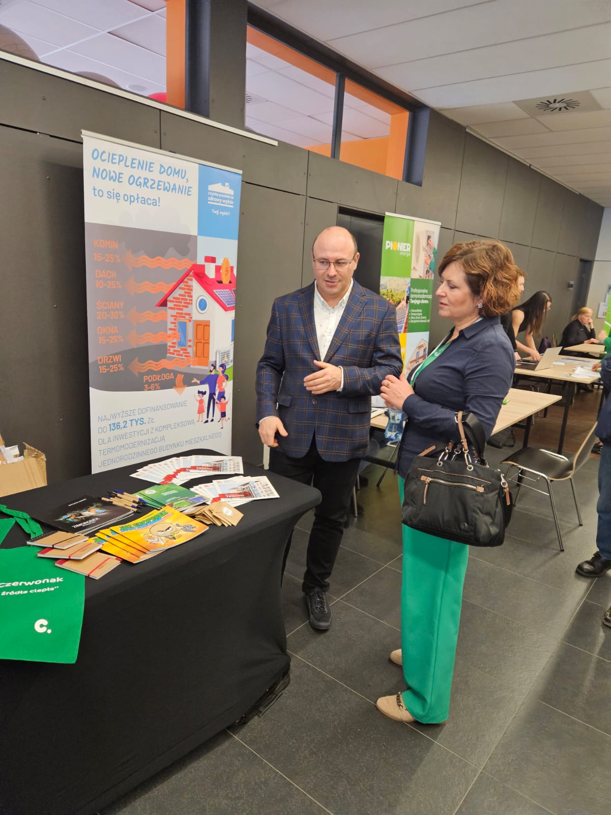 Stoisko WFOŚiGw w Poznaniu. Przy stoisku stoi uczestniczka konferencji i doradca WFOŚiGW w Poznaniu, który udziela informacji.