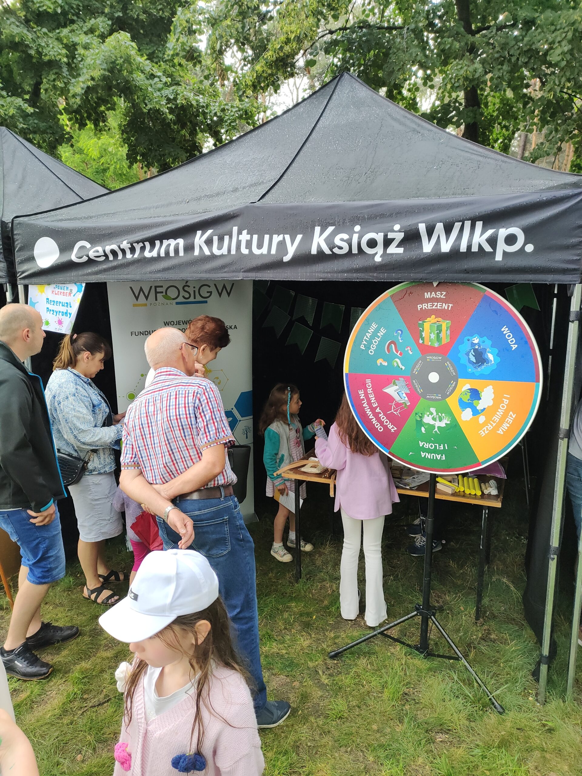 Stoisko WFOŚiGW w Poznaniu, pod namiotem widać koło fortuny i kręcące się wokół dzieci.