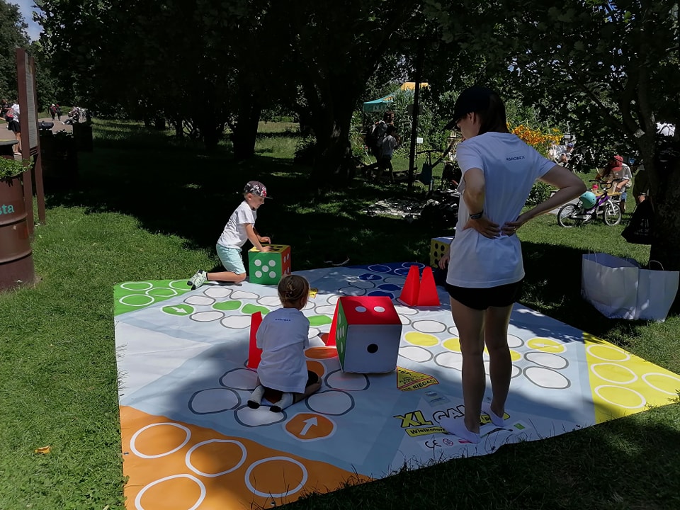 Na zdjęciu zabawa dzieci na dużej macie plenerowej.