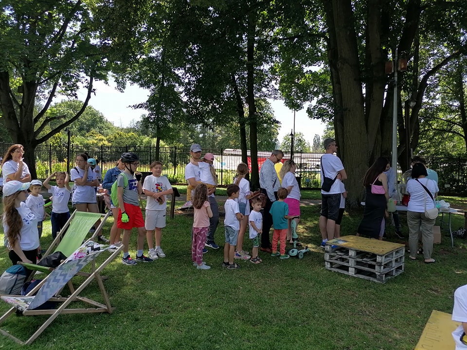 Zdjęcie przedstawia rodziny podczas pikniku po grze miejskiej "Przygoda z Tatą".