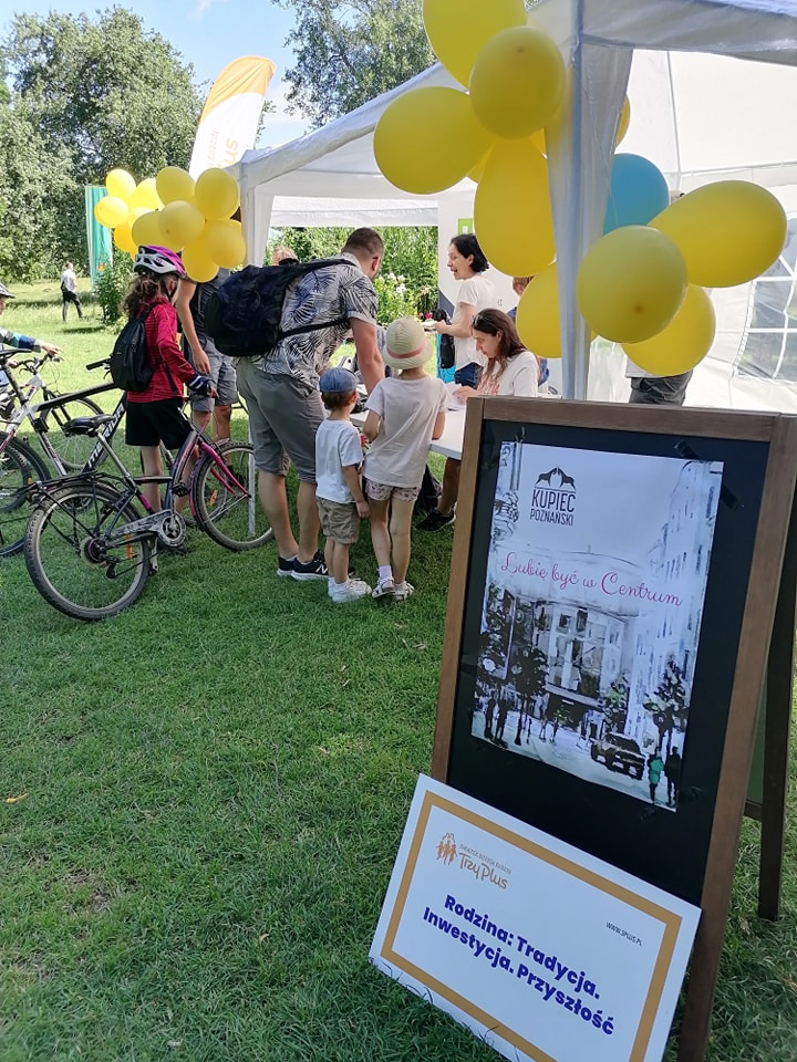 Na zdjęciu jedno ze stoisk podczas pikniku i rodziny uczestniczące w grze miejskiej.